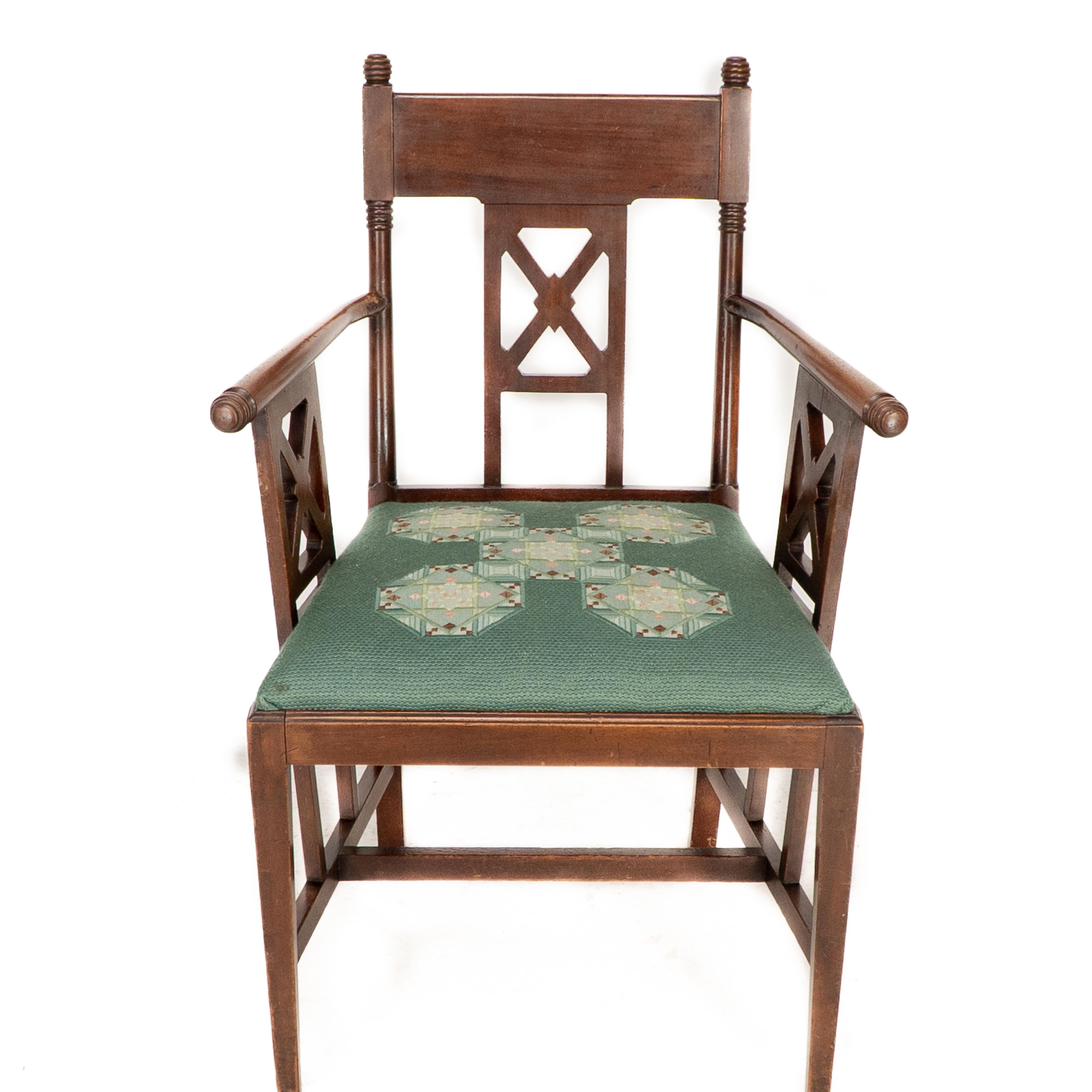 William Birch. Poltrona in noce in stile Aesthetic Movement con terminali a sfera torniti sulla parte superiore e sulla parte anteriore dei braccioli, con decorazioni incrociate sullo schienale e sotto i braccioli; i supporti laterali delle barelle