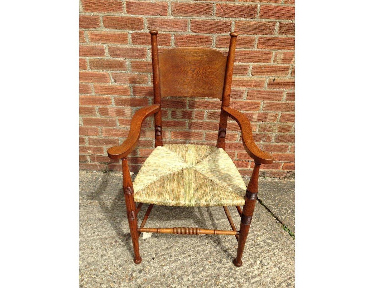 William Birch. A classic English Arts and Crafts oak rush seat dining or office armchair. 
This style of dining chairs was retailed by Liberty & Co. London.
Professionally re rushed.