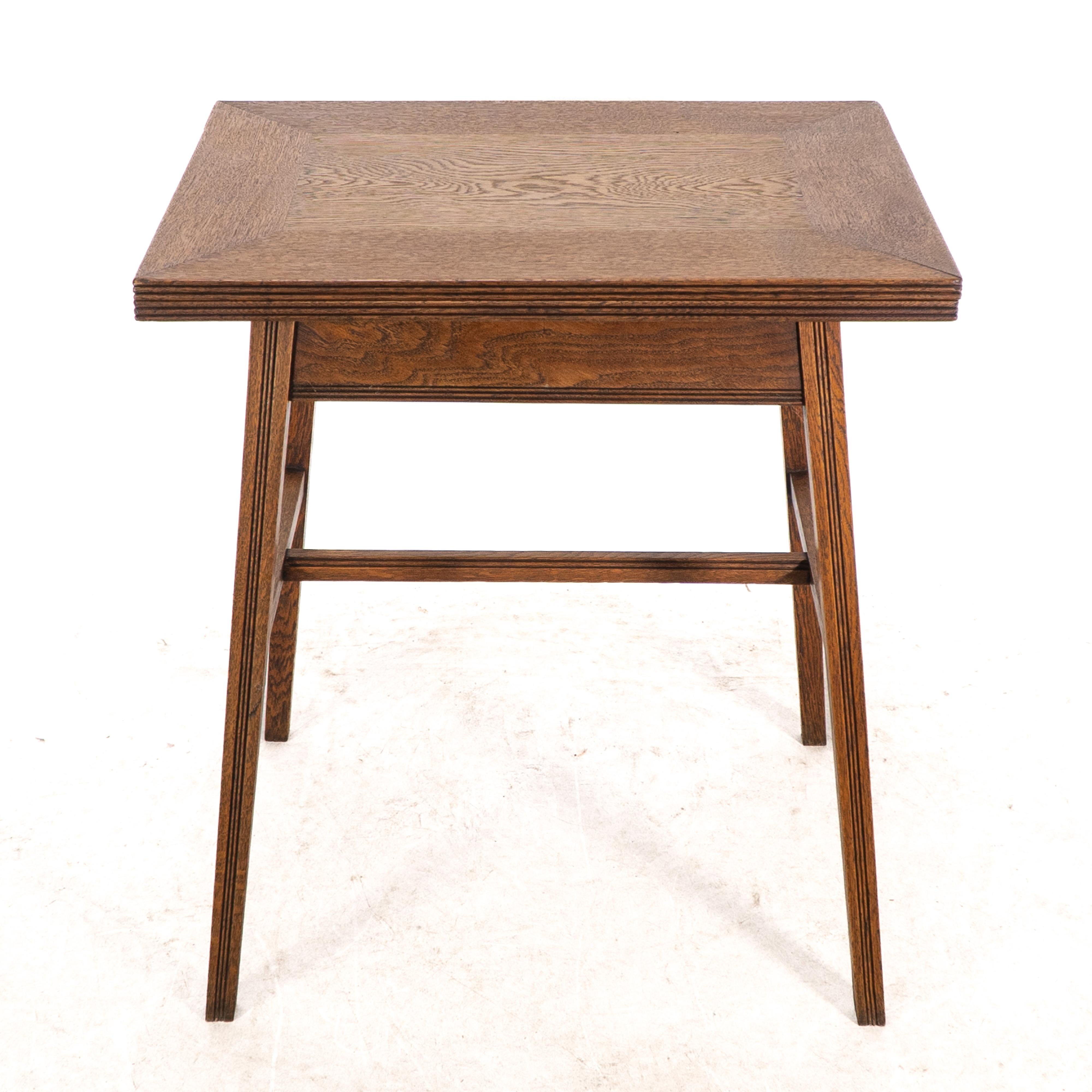 William Birch. An Arts and Crafts oak side, card or games table with a swivel and fold out top. The top with large mitered corner joints, stood on tapering legs united by a H stretcher with scribed tramline decoration.Folded: Height: 75 cm x Width