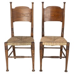 William Birch per Liberty & Co. Coppia di sedie Arts & Crafts in legno di quercia con seduta in giunco