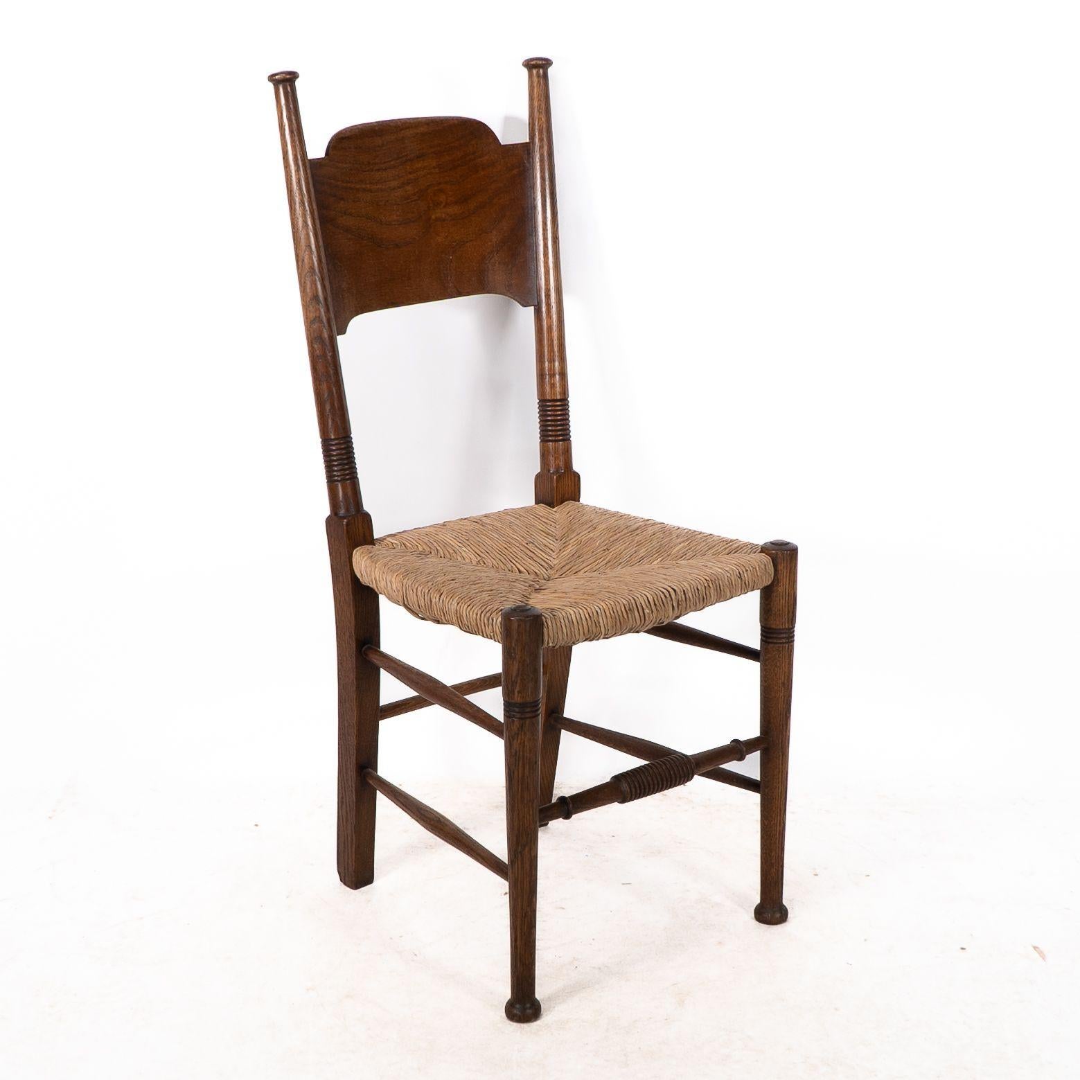 William Birch. Liberty and Co retailer. A classic Arts and Crafts rush seat oak dining chair with a wide curved headrest and attractive wild grain. Ring turned legs with ring turned front stretchers.
These timeless designs were unique to William