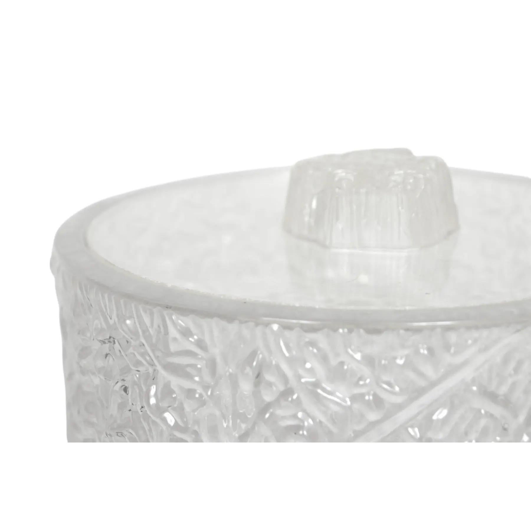 A mid-century Lucite ice bucket by William Bounds Grainware. The bucket and lid are cast with a textured exterior that gives the look of ice. The lid lifts off with an iceberg shaped handle.