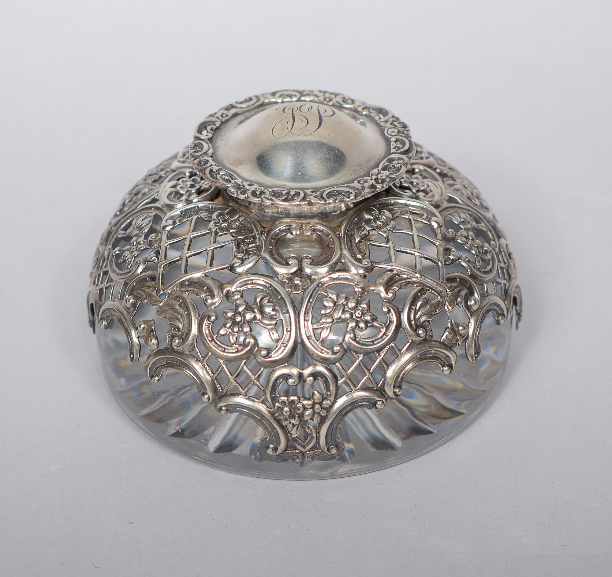 Large Victorian inkwell by William Comyns. This has a repousse sterling design over a heavy crystal inkwell. The hinged lid is monogrammed with a JP. The piece is dated 1895.