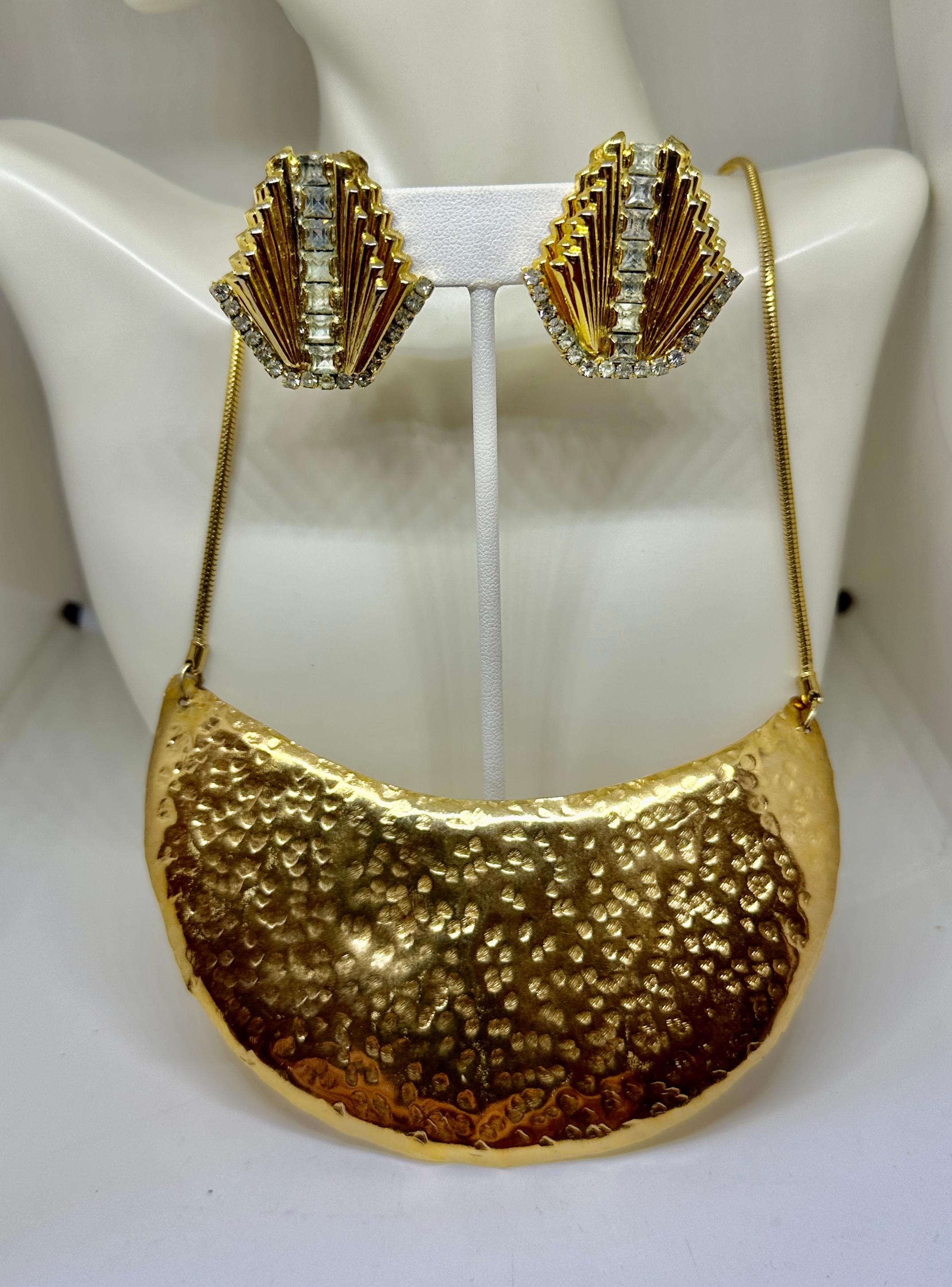 Lasciati conquistare da questa favolosa collana a pettorina in metallo dorato martellato di William De Lillo e dagli orecchini con strass di De Lillo.  I favolosi gioielli firmati de Lillo sono un tesoro da trovare.  Questa meravigliosa collana con