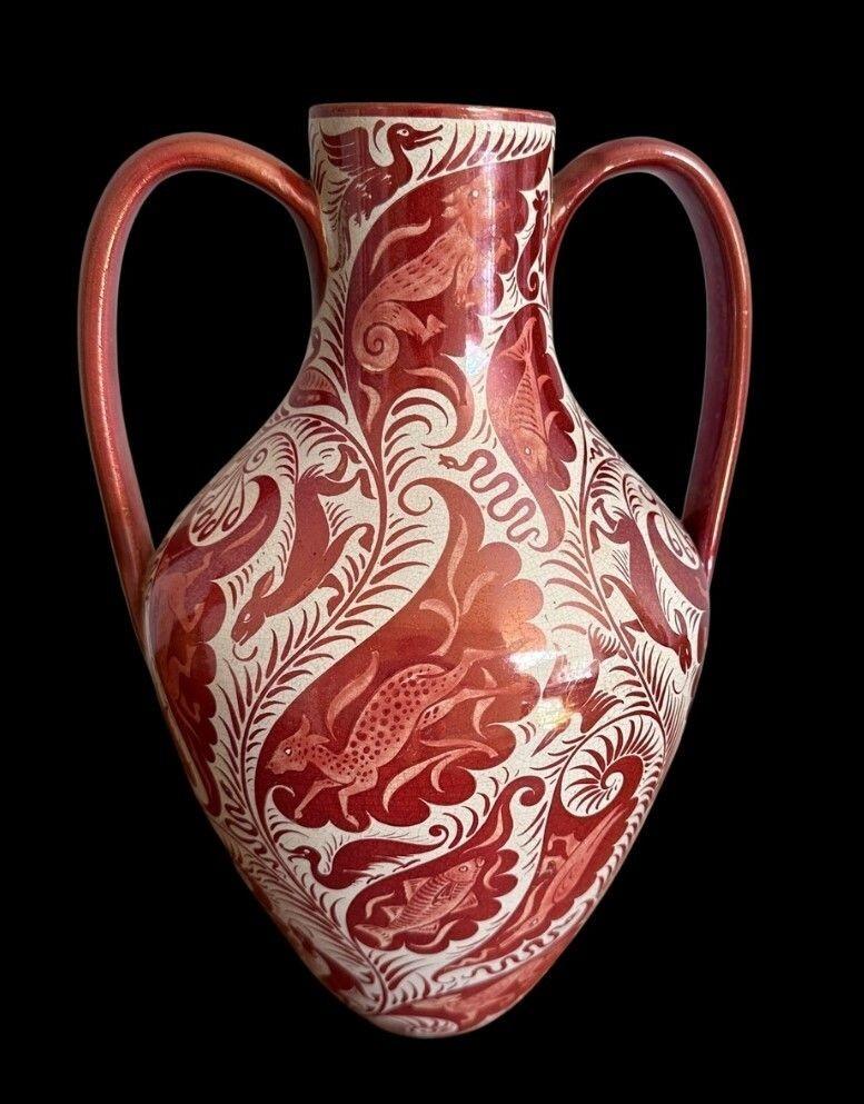 5440
William De Morgan Twin Handled Vase profusely decorated with Animals, Fish and Birds in a Ruby Lustre Glaze.
Restoration to one Handle and light crazing
Tulip mark for C 1890
32cm high, 21.5cm wide