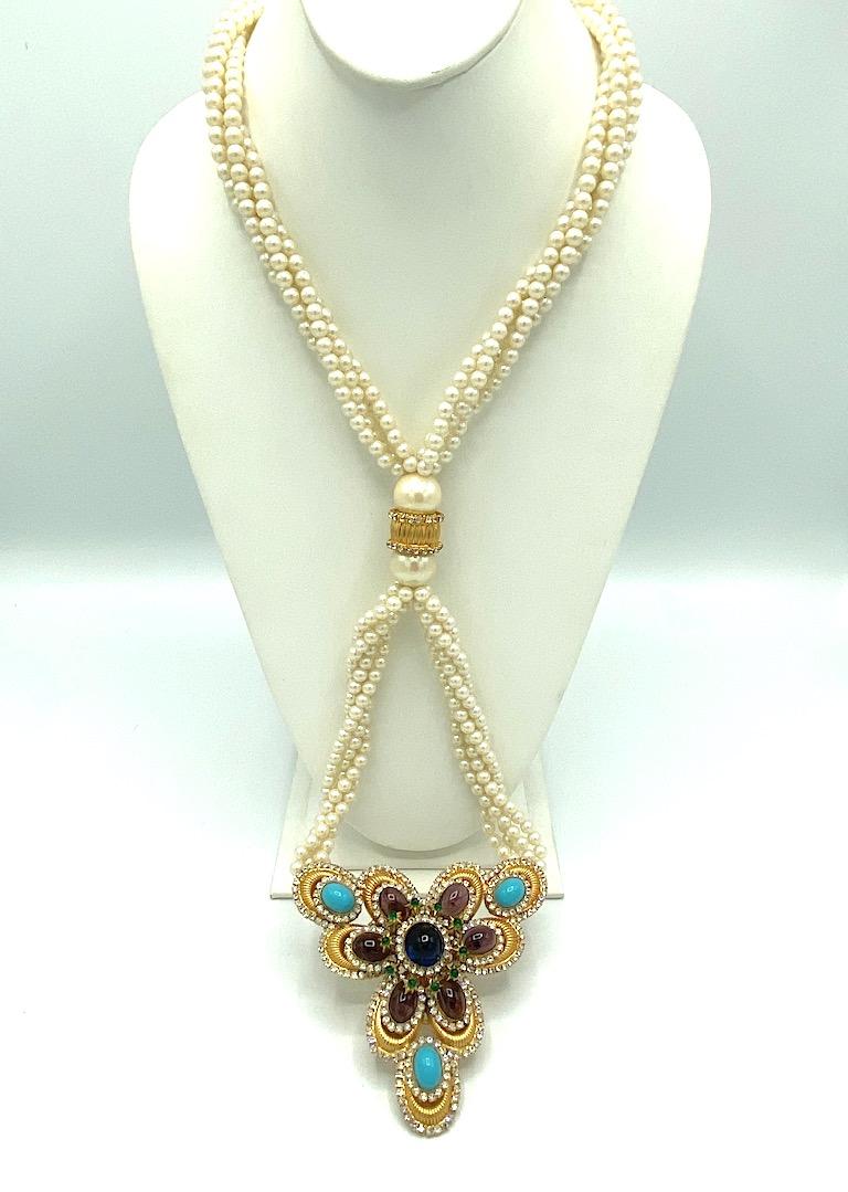A beautiful, rare and opulent William DeLillo necklace from the early 1970s. It is comprised of four strands of faux pearls worn twisted or not around the neck. They meet at the bottom at a group of two faux pearl and rhinestone set fluted gold
