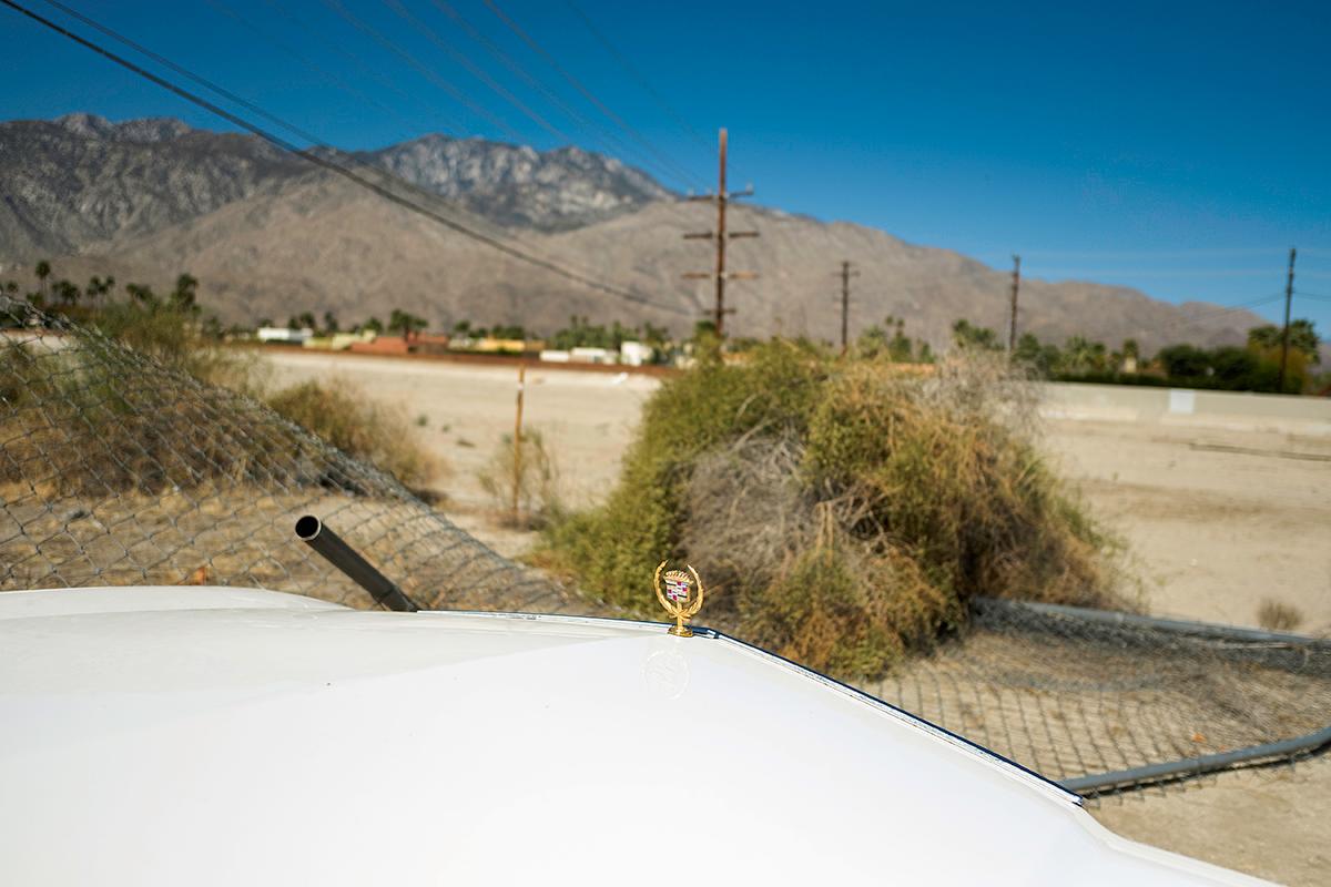 William Greiner Figurative Photograph – Weißer Cadillac, Palm Springs, CA – Auto, Wüste, Landschaft, Berge, Nahaufnahme