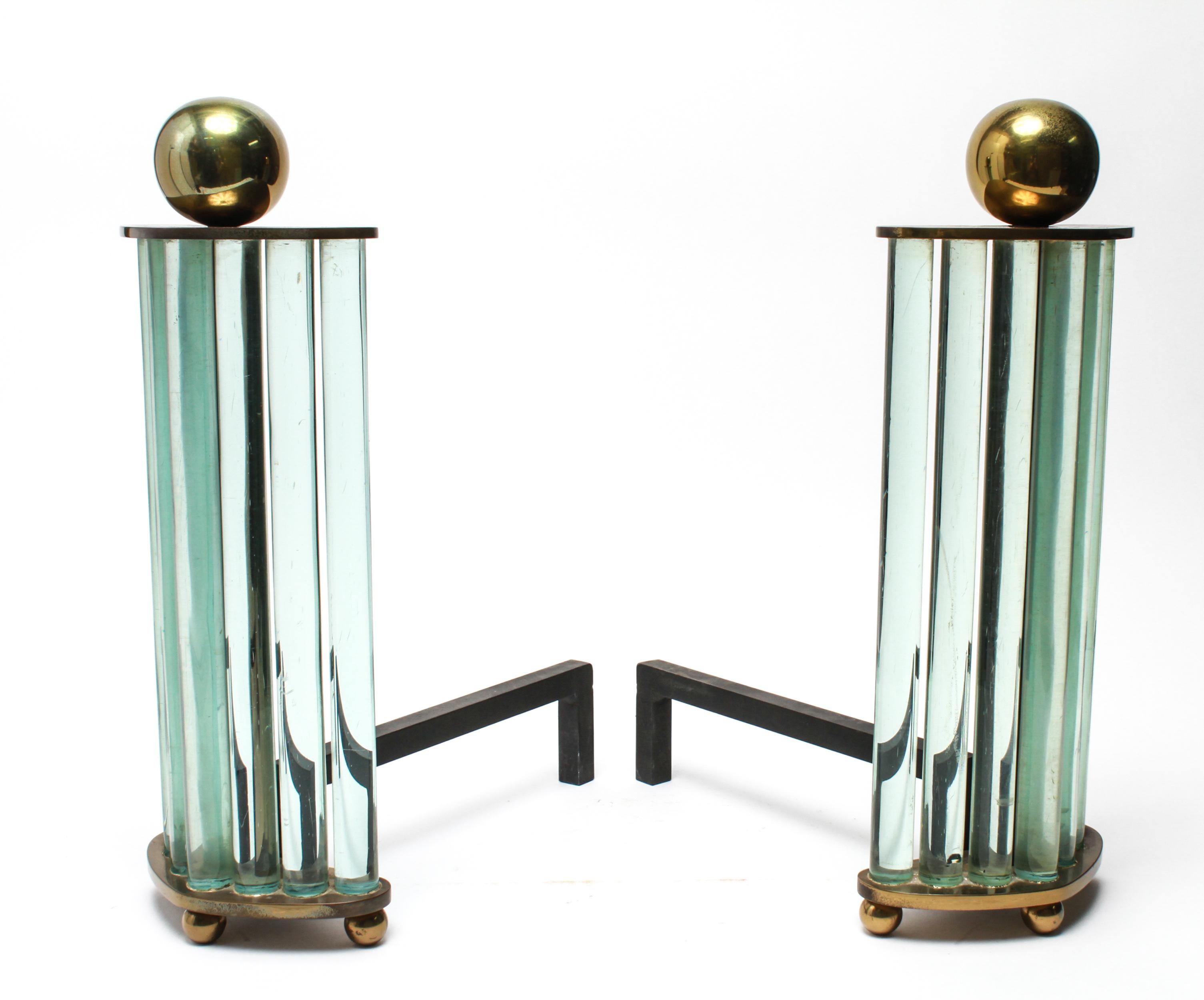 Modernist pair of andirons made by the William H. Jackson Company in New York City. The pair has spherical brass finials atop rising glass rods mounted on a brass base. Maker's label on the underside. In great vintage condition with age-appropriate