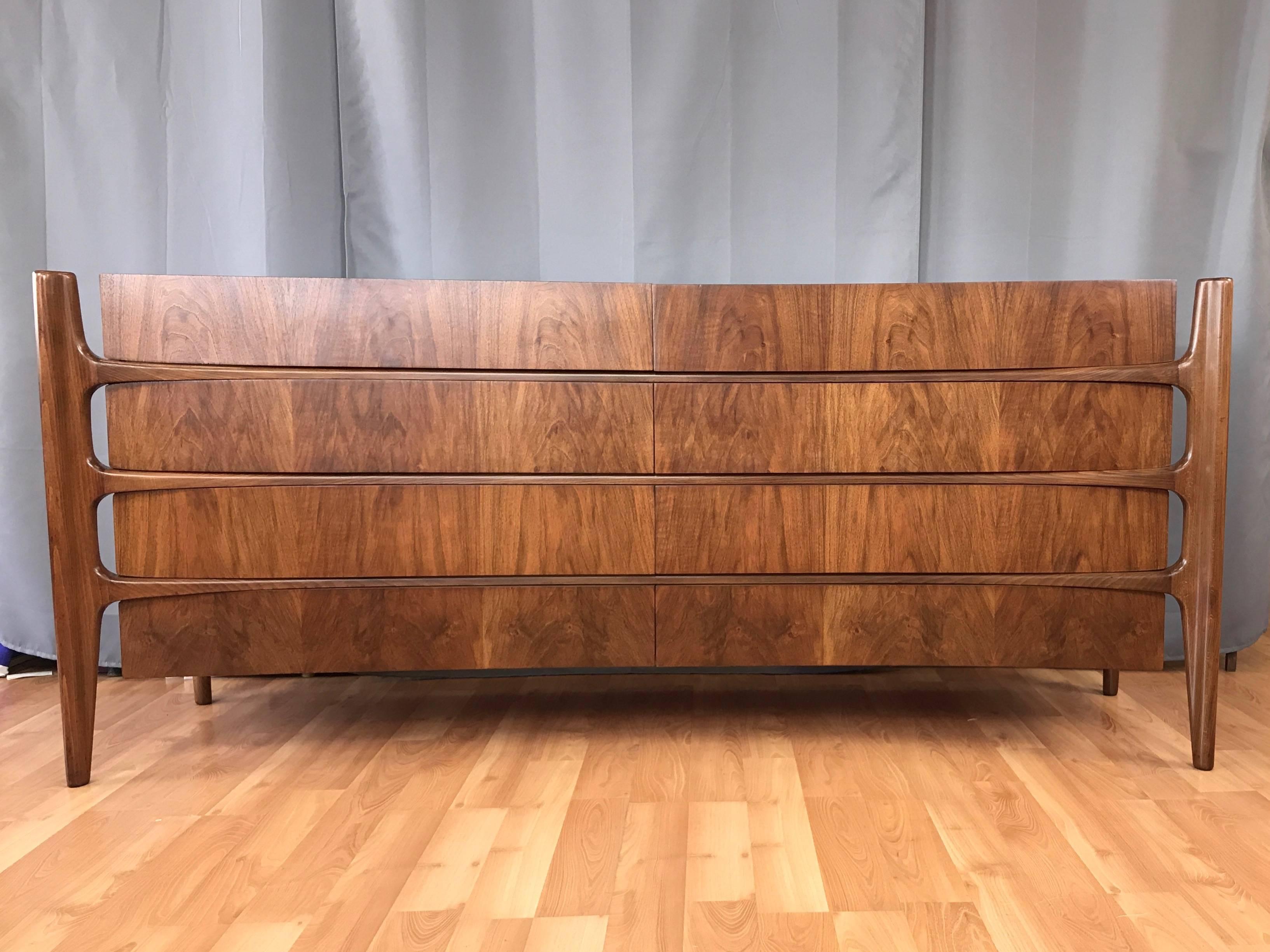 A spectacular circa 1950 sculptural eight-drawer dresser in walnut by William Hinn for Urban Furniture, and realized by Swedish Furniture Guild.

Exposed biomorphic frame of exquisitely hand-sculpted solid walnut intersects and supports a