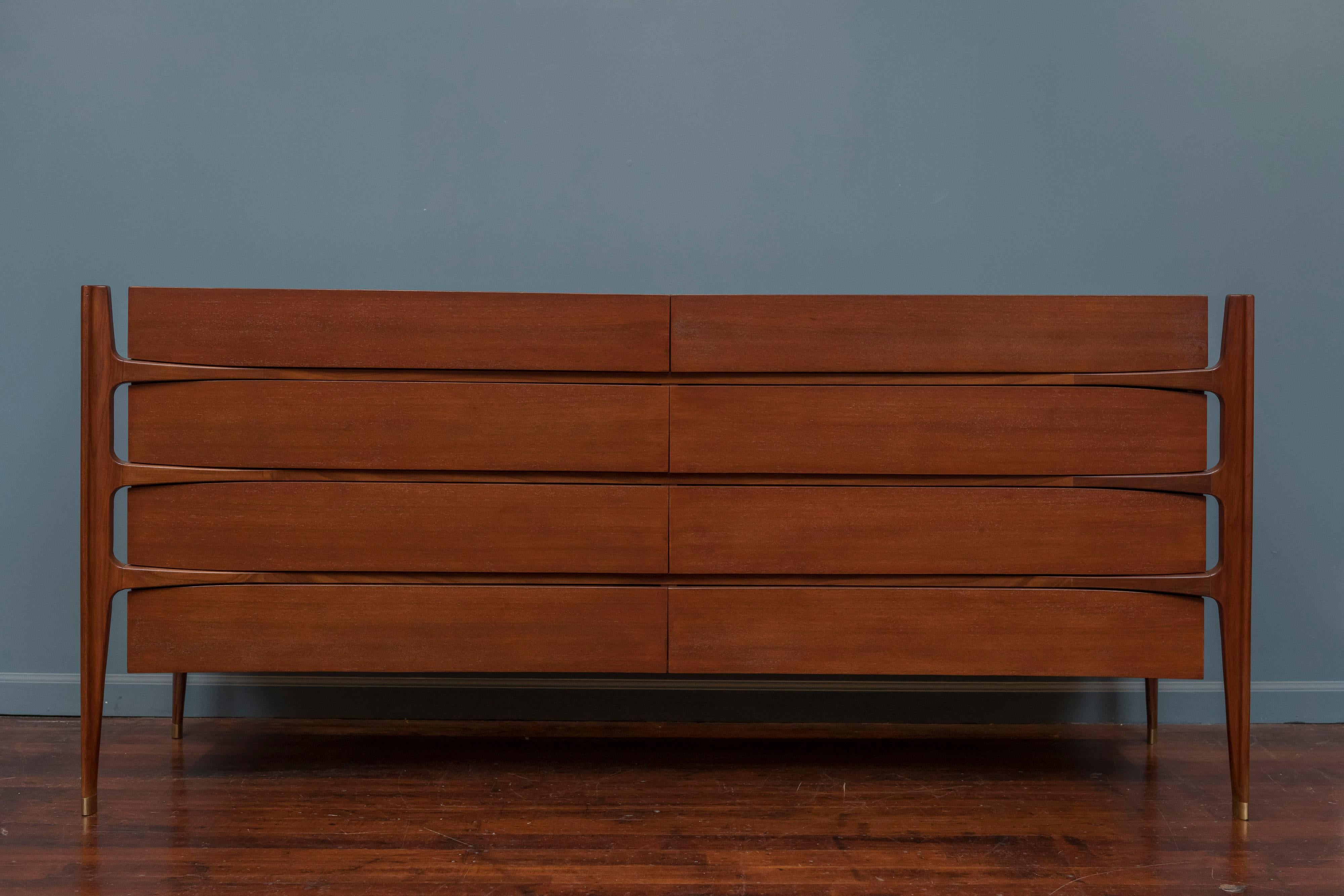 A spectacular circa 1950 sculptural eight-drawer dresser in walnut by William Hinn for Urban Furniture, and realized by Swedish Furniture Guild. Exposed biomorphic frame of exquisitely hand-sculpted solid walnut intersects and supports a beautifully