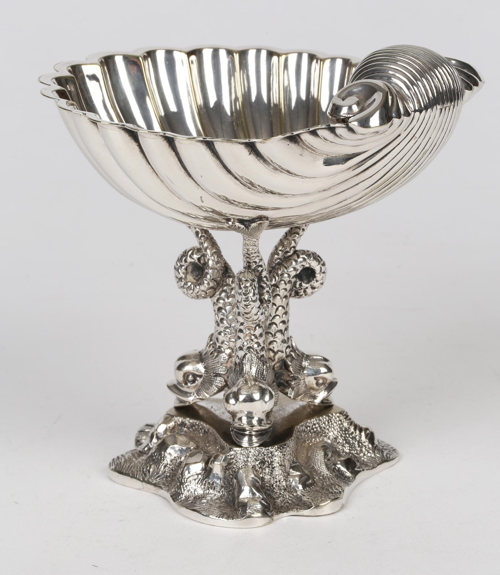A very fine and decorative Aesthetic Movement silver plated shell shaped bon-bon dish by William Hutton and dating from around 1890. This attractive dish stands raised on a moulded leafy rocky pedestal base with three dolphin supports with the dish