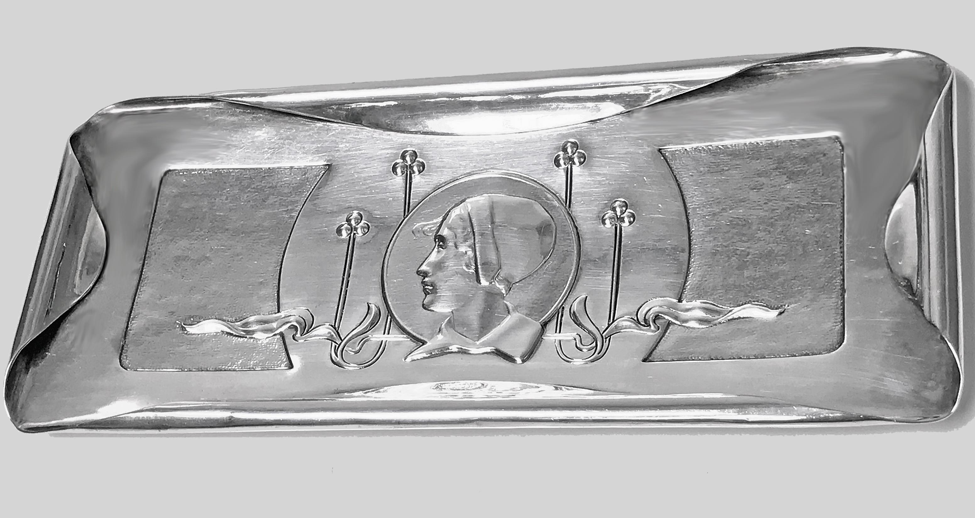 William Hutton Art Nouveau silver tray, London, 1901. The rectangular small tray with curvilinear fold over border; the centre depicting art nouveau decoration with female portrait in period costume, accented with lightly textured panels. Measures: