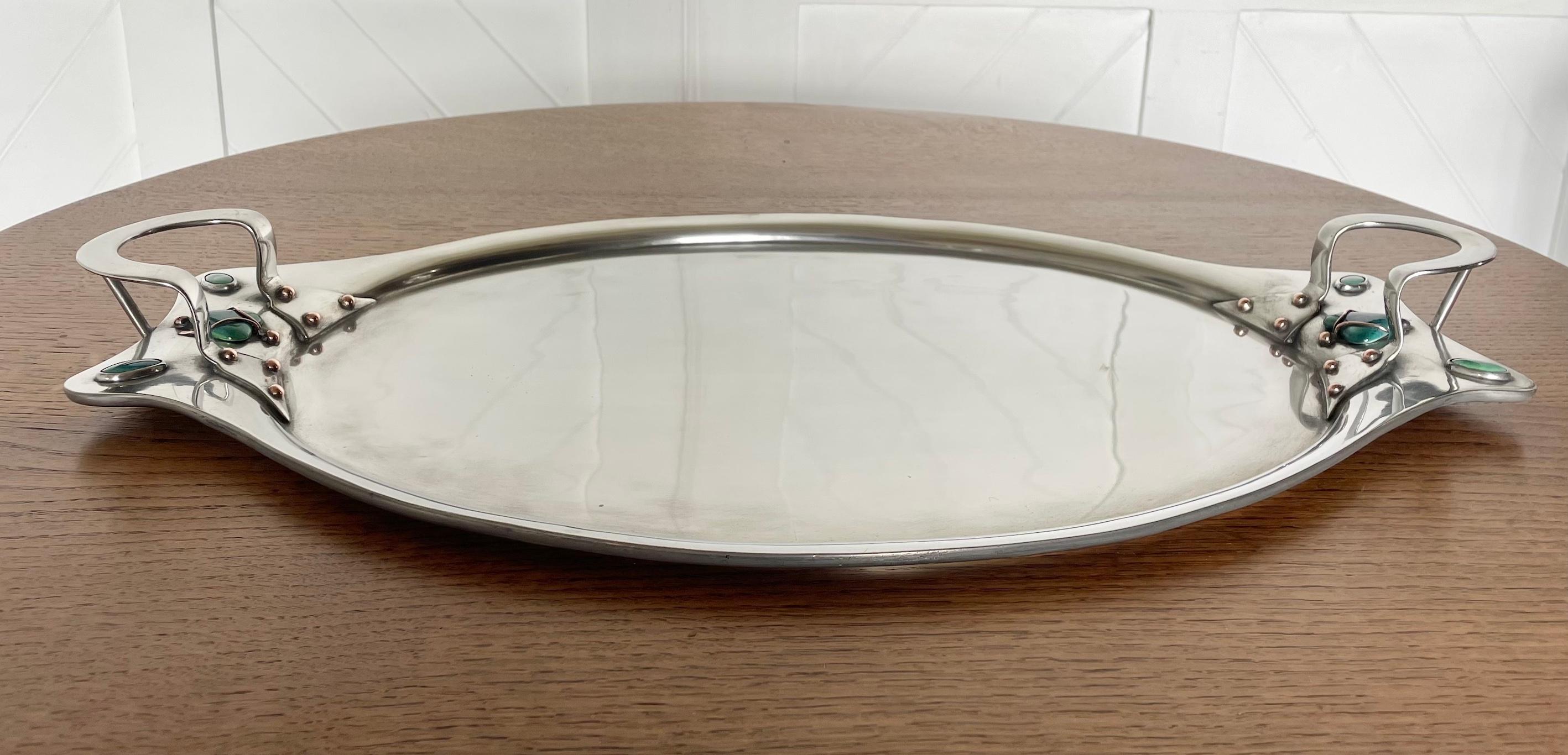 Arts & Crafts pewter oval tray

With heart shaped clasped ceramic Ruskins 

and 4 inset oval ceramic Ruskins either side 

Circa 1900

Height 6cm. Width 59cm.  Depth 35cm