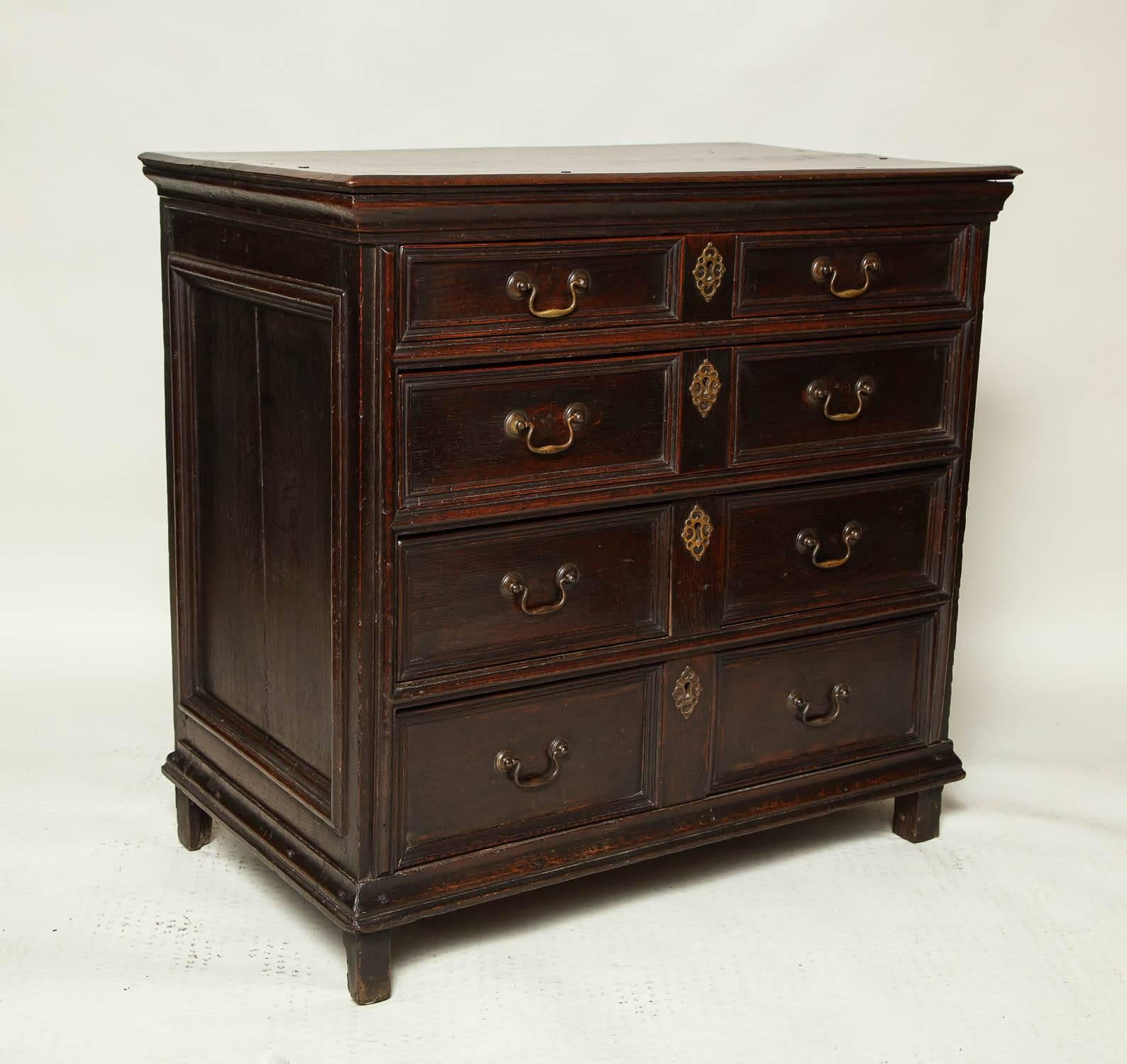 Fine English late 17th-early 18th century geometric oak chest of drawers, the beveled edge top over four graduated drawers having double molded panels, the side panels similarly molded and standing on original stile feet, the whole with excellent