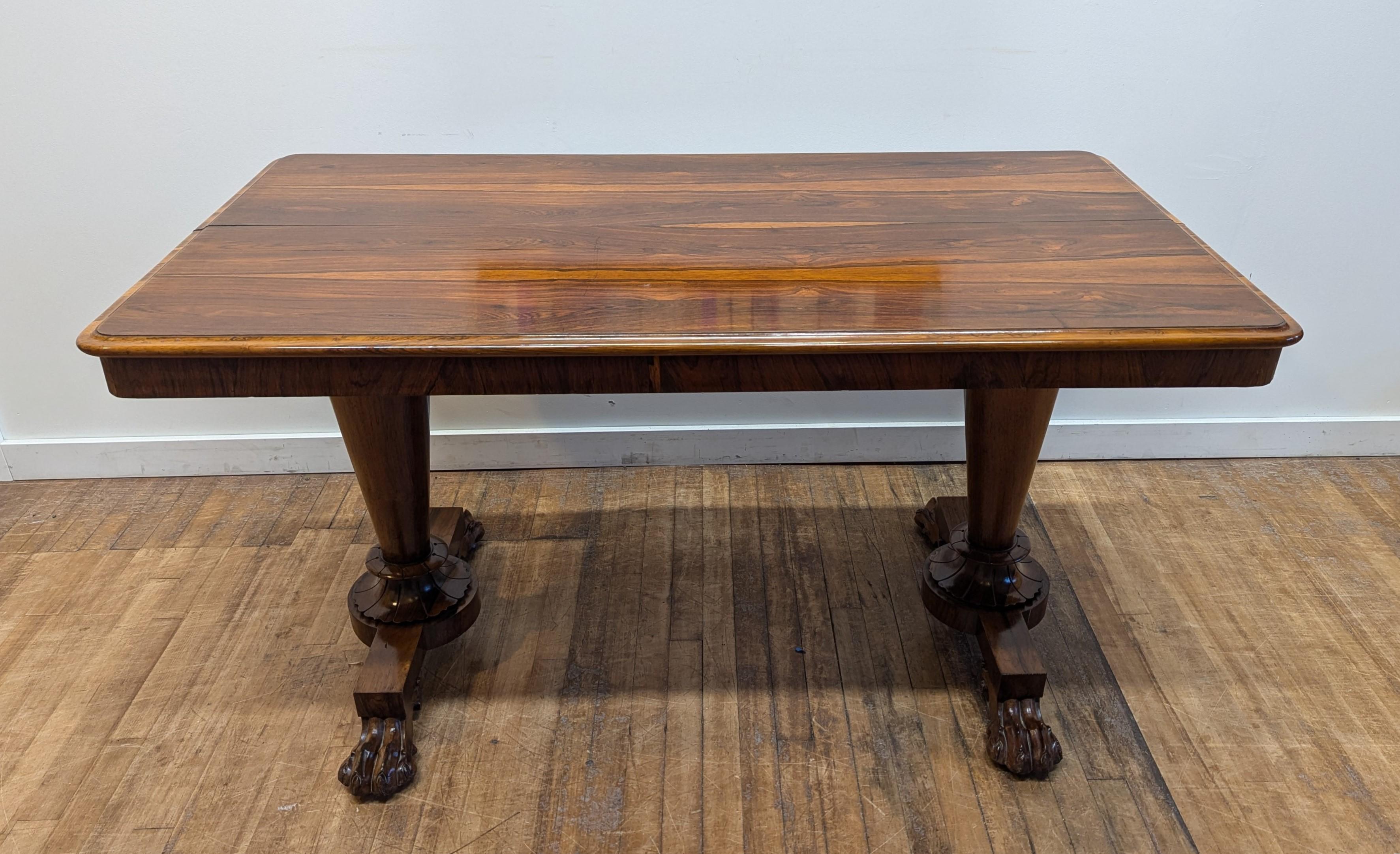 Bureau de bibliothèque en bois de rose William IV.   Merveilleuse table de bibliothèque William IV du 19e siècle avec plateau en bois de rose à bord et jupe moulurés, tablier à bandeau en bois de rose reposant sur deux piédestaux circulaires effilés