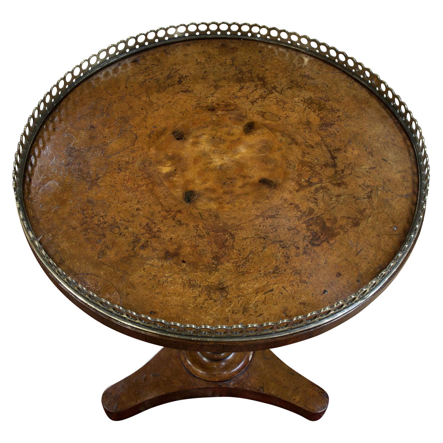 A William IV burr elm circular occasional table with brass gallery on a baluster turned column on triform base,

circa 1830.