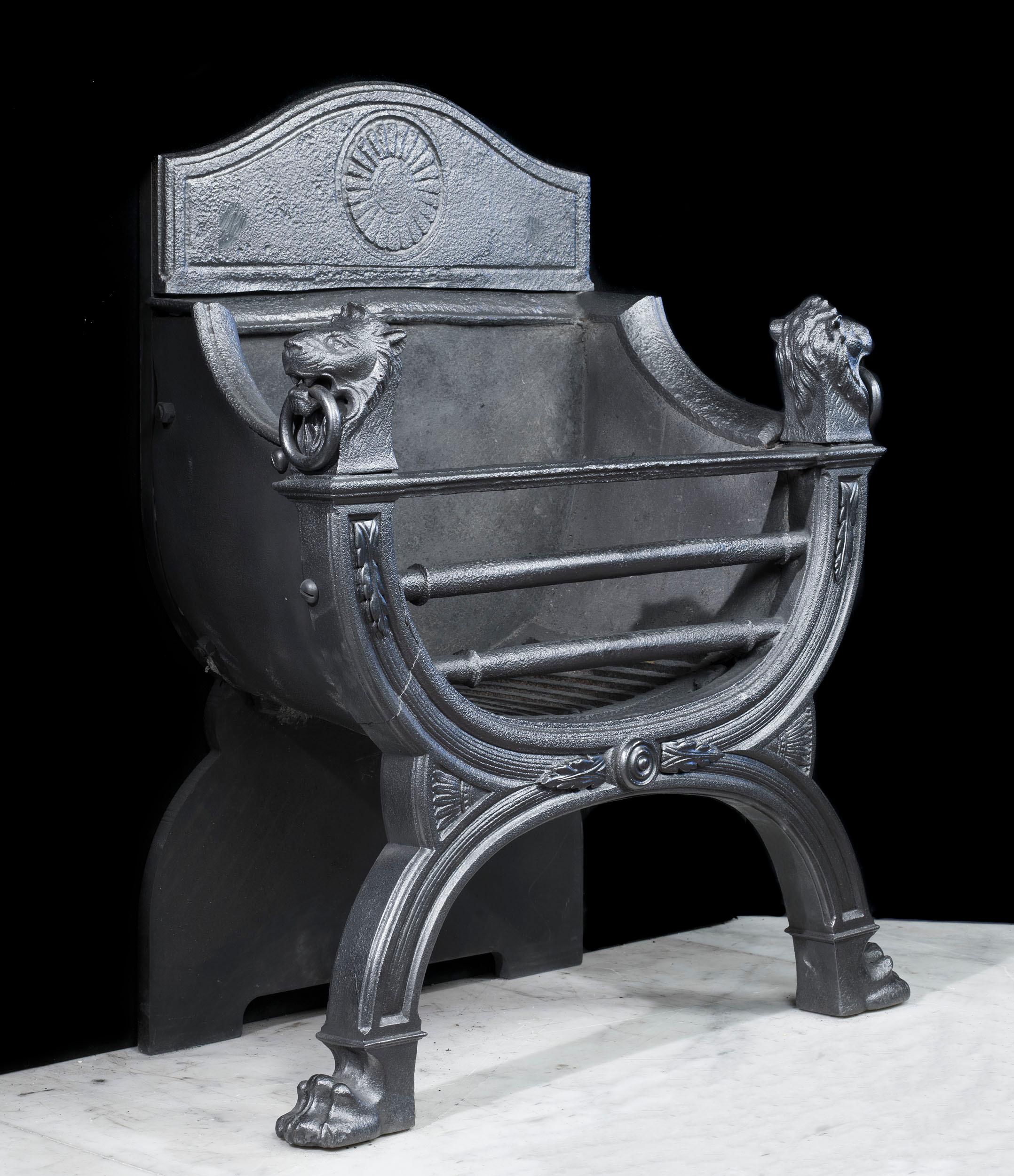 A charming William IV cast iron fire basket in a shape reminiscent of a Savonarola chair, adorned with ringed lion masks.
English, circa 1830.
