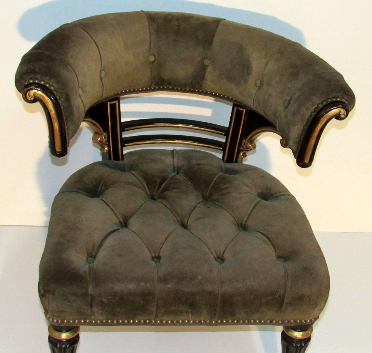William IV curved back armchair, with wooden and gilt detail, upholstered in tufted leather and resting upon brass casters, from a project by Peter Marino.