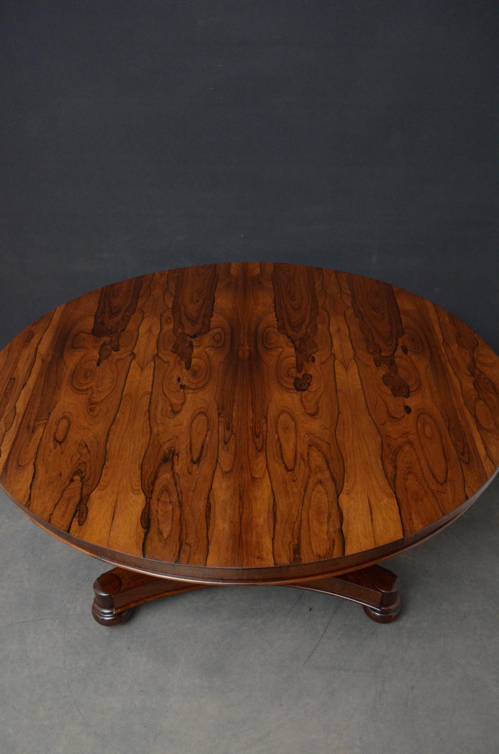 Sn4929, fine quality rosewood breakfast table, having a tilt-top with stunning rosewood grain on flat faceted column terminating in circular collar and trefoil base, all standing on original bun feet and castors. This antique dining table has been