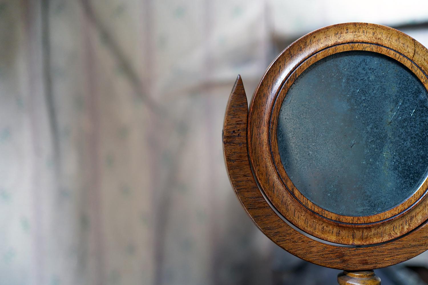 The William IV to early Victorian period oak gentleman’s shaving mirror having the original foxed mirror plate, to a semi elliptical crescent moon frame to a turned stand and draught turned base and surviving from the second quarter of the