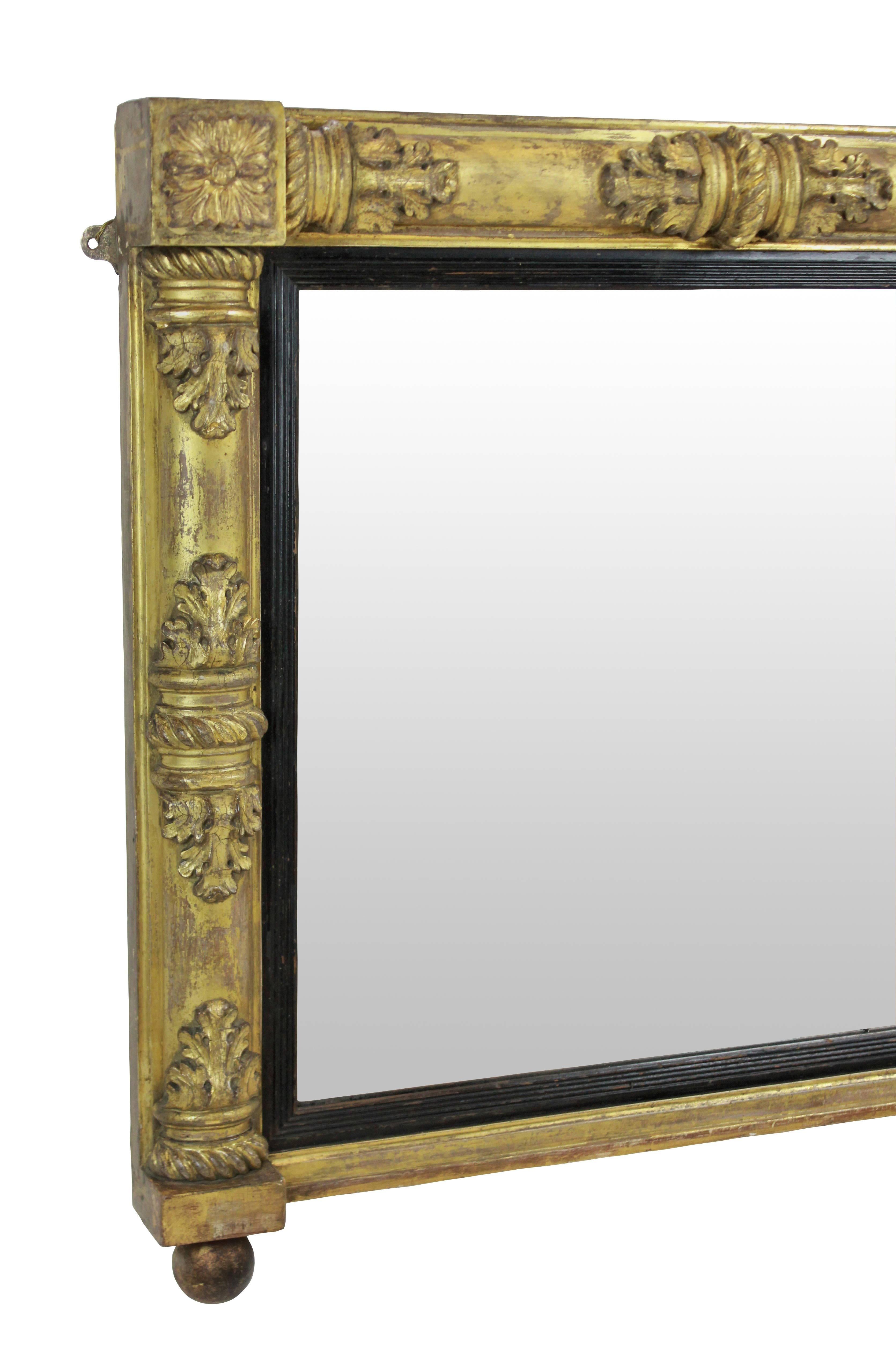 A finely carved and water gilded William IV overmantel mirror, with ebonized slips, mercury plate and depicting acanthus leaves.