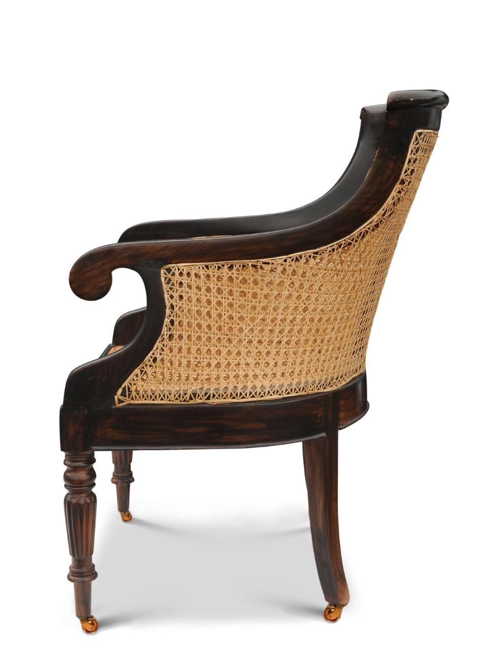 Stylish William IV 1700's Hardwood Cane Bergere Library Armchair With Scrolled Arms and Original Brass Castors on Fluted Supports.

Additional dimensions: 
Height to seat 41cm I Height to arms 69cm
Seat width: 54cm I Seat depth: 52cm