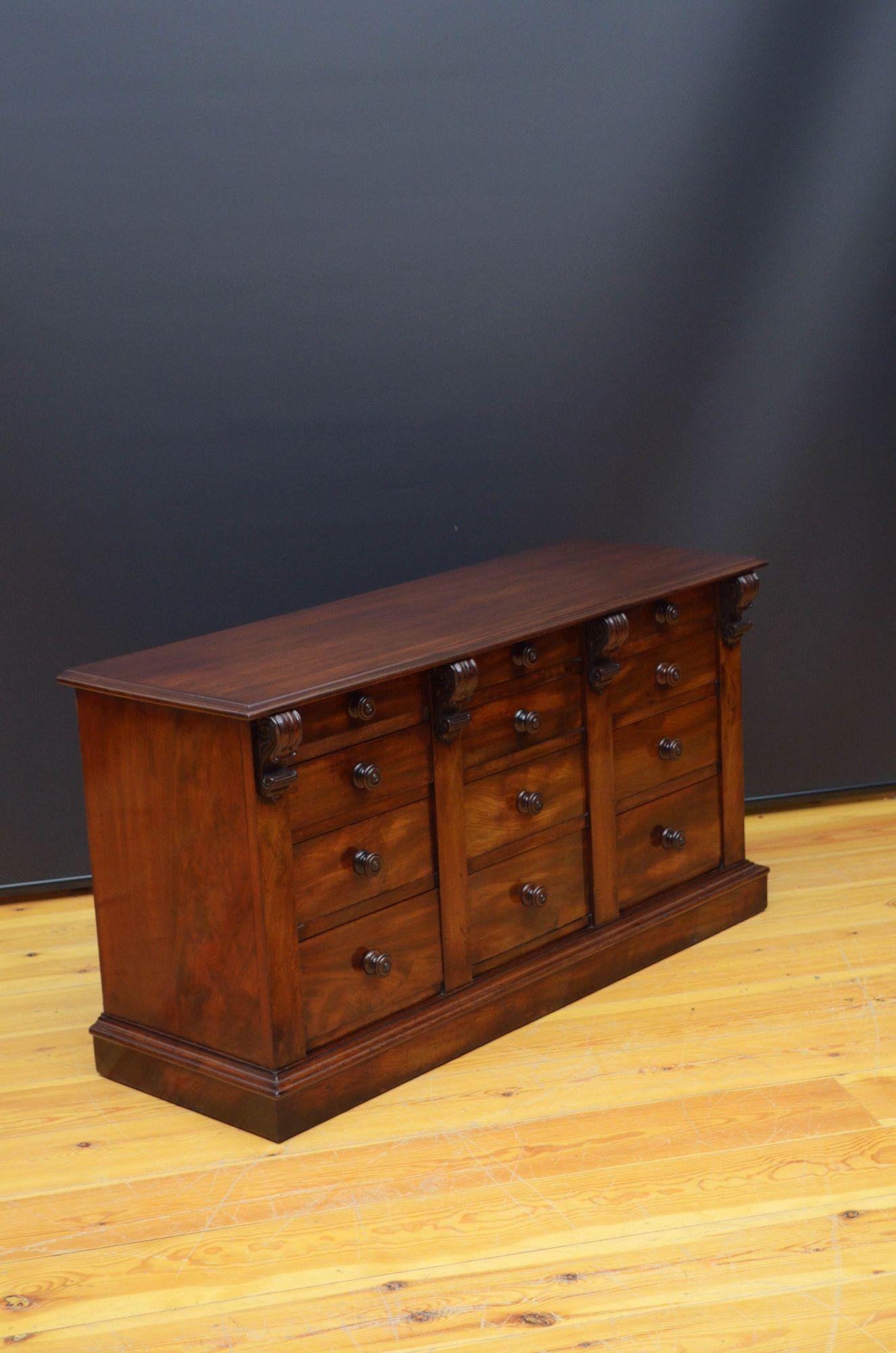 St046 William IV mahogany chest of drawers of low proportions having solid, figured mahogany top with moulded edge above three banks of four graduated, figured mahogany drawers, all fitted with original turned knobs and flanked by fine drop
