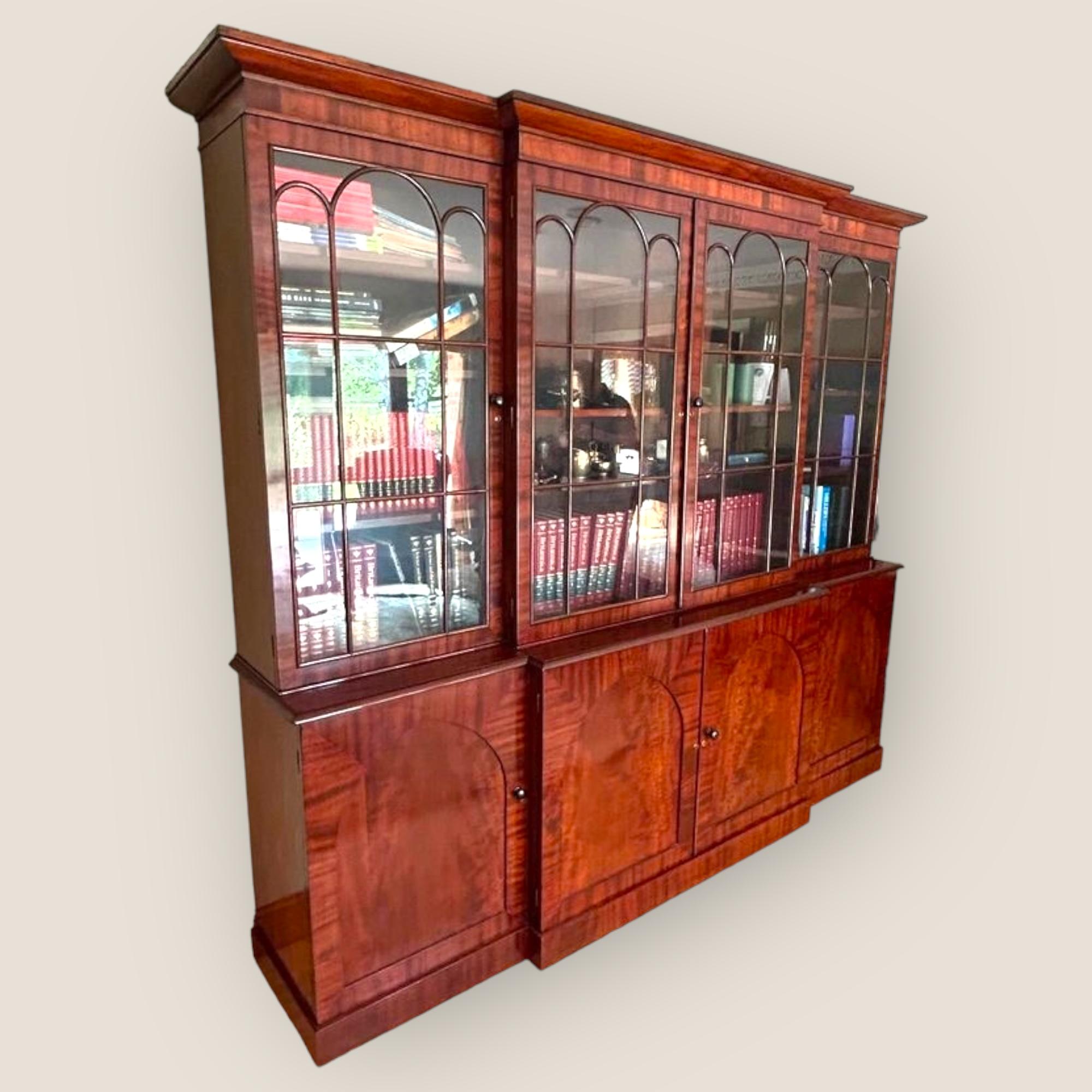Una grande libreria in mogano William IV, con 4 porte vetrate sopra le porte di un armadio a pannelli.