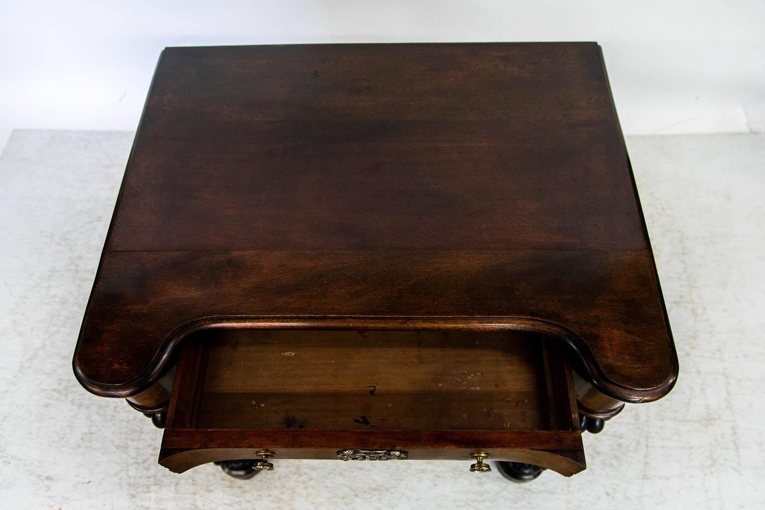 The top of this side table is solid mahogany. The corners curve out to meet the carved support columns. The drawer front and apron extend all the way around to the back. It was made with highly figured burled walnut. The bullnose molding follows the