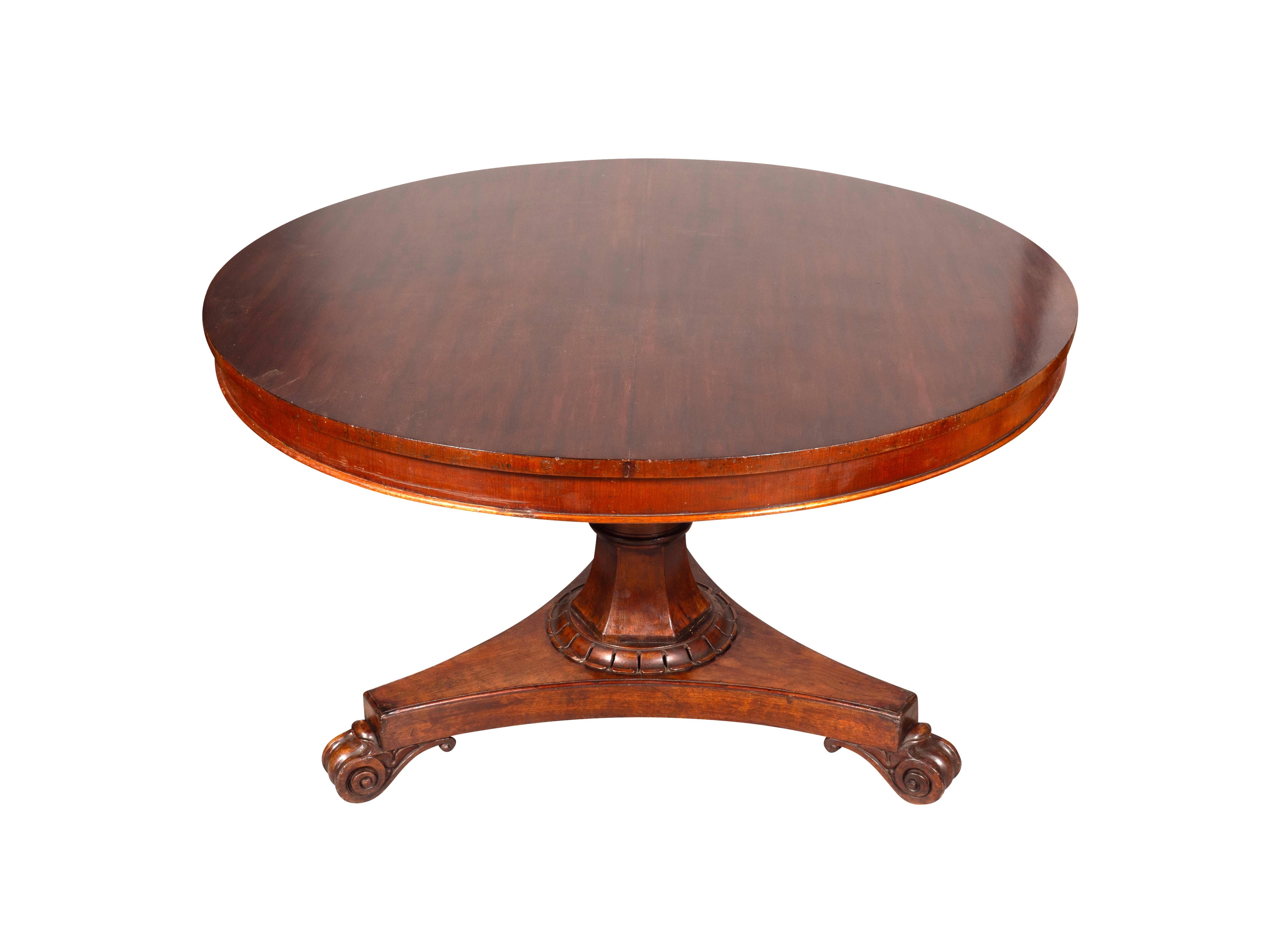 Circular with conforming apron. Shaped octagonal tapered support ending on a tripartite base with scroll feet.