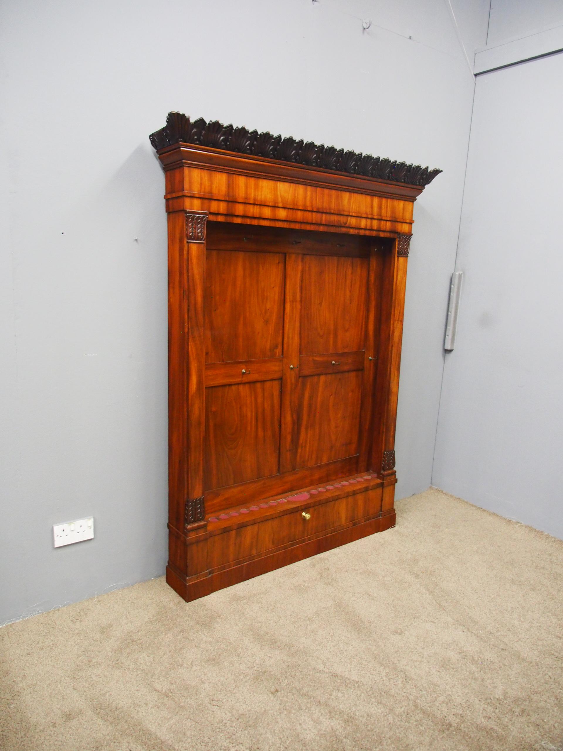 William IV mahogany cue rack or stand, circa 1840. With a hand-carved, acanthus leaf design to the pediment and cornice above a shaped flame mahogany frieze, leading on to further acanthus leaf carving to the pilasters either side. The recess is in
