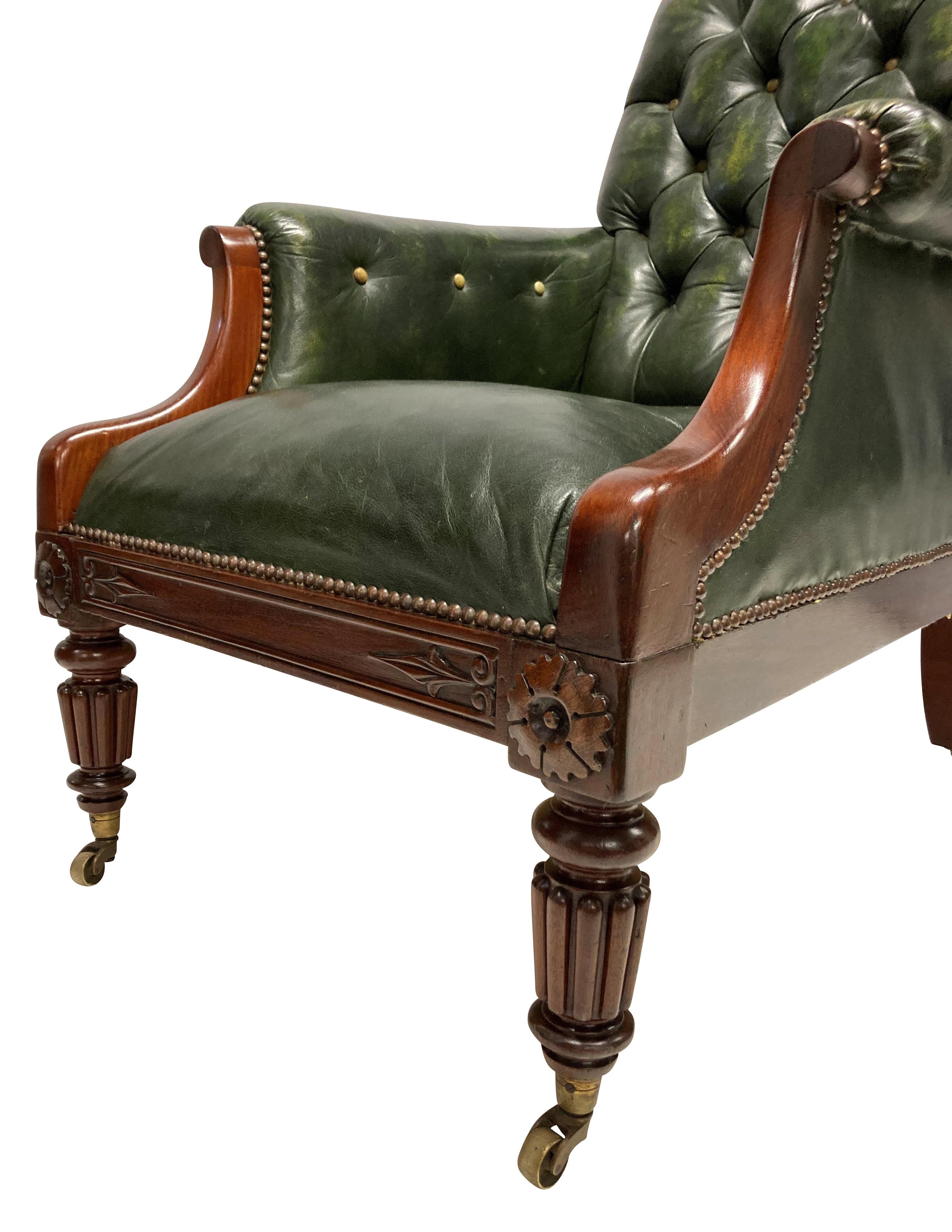 An English, William IV mahogany library chair, with fluted legs and anthemion decoration. It has been upholstered in green leather, with buff leather buttoning.