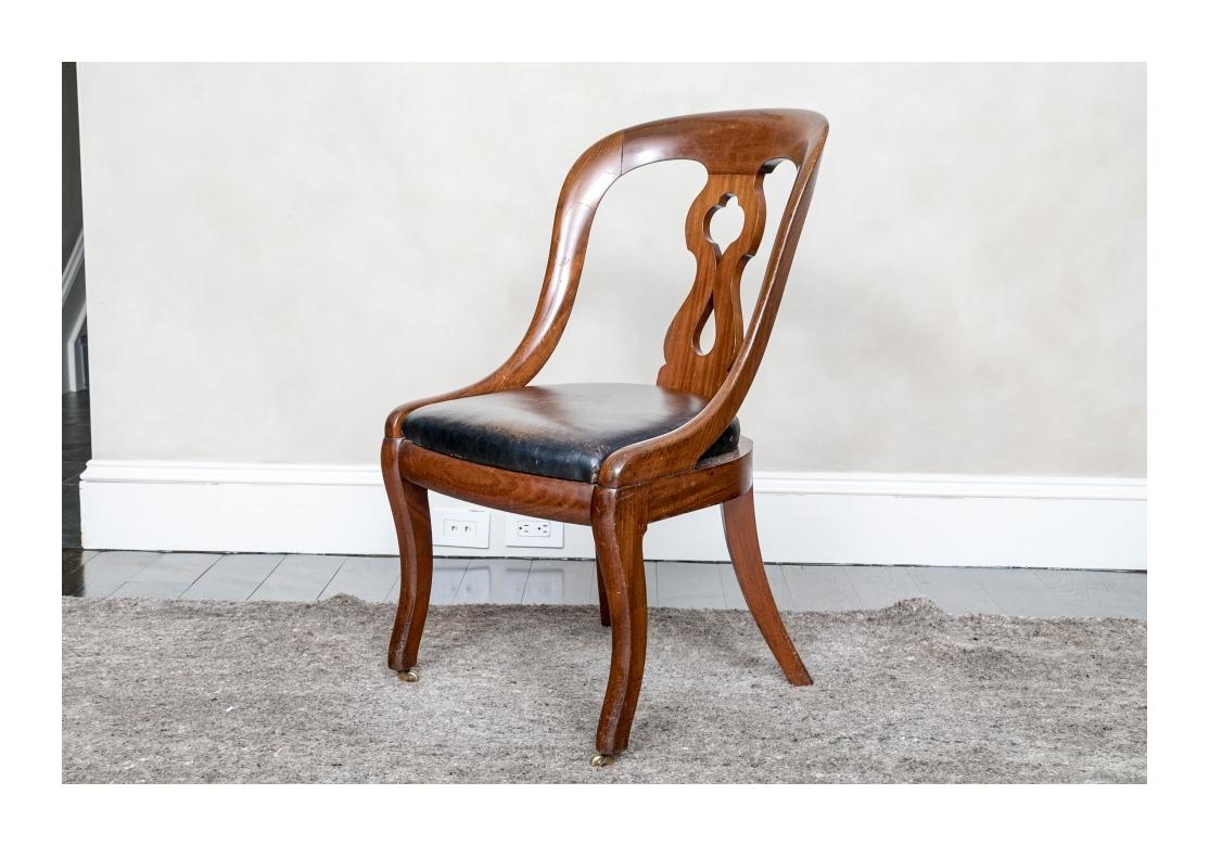 A fine original condition Library Chair with Leather Seat. The  frame with handsome wood graining, pierced splat back, and overall sinuous form and having castored front legs. With good weight and quite comfortable and the frame with fine age patina