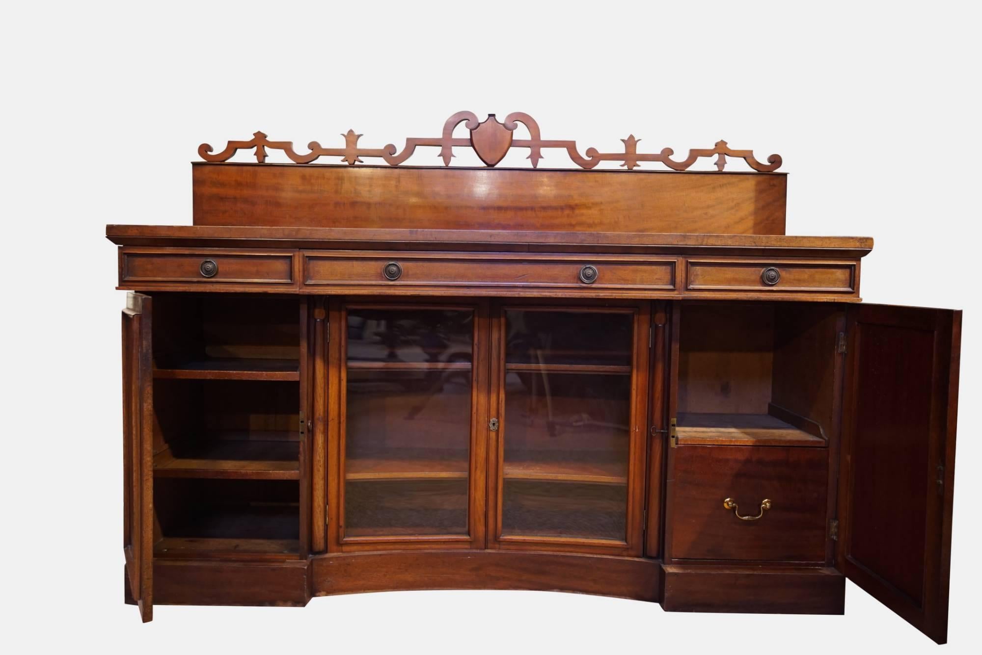 A William IV mahogany sideboard comprising 3 drawers to the box top, the base and inverted breakfront with 2 concave glazed doors flanked by 2 paneled doors,


circa 1835.


 