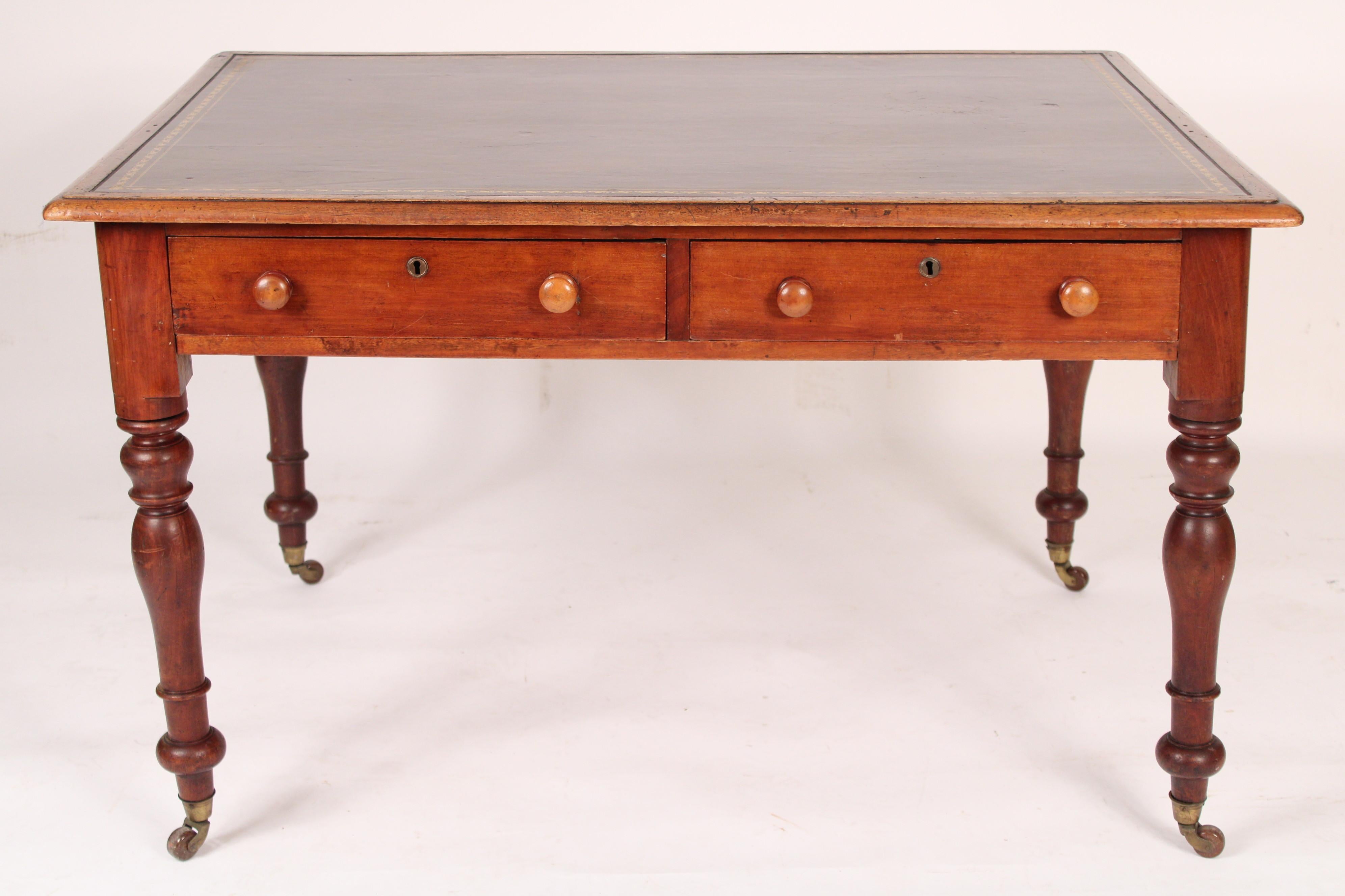 William IV mahogany writing table with a tooled leather top, circa 1835. With a mahogany top inset with a late 20th century tooled leather top, two frieze drawers, turned legs resting on brass casters. Knee clearance 22.5