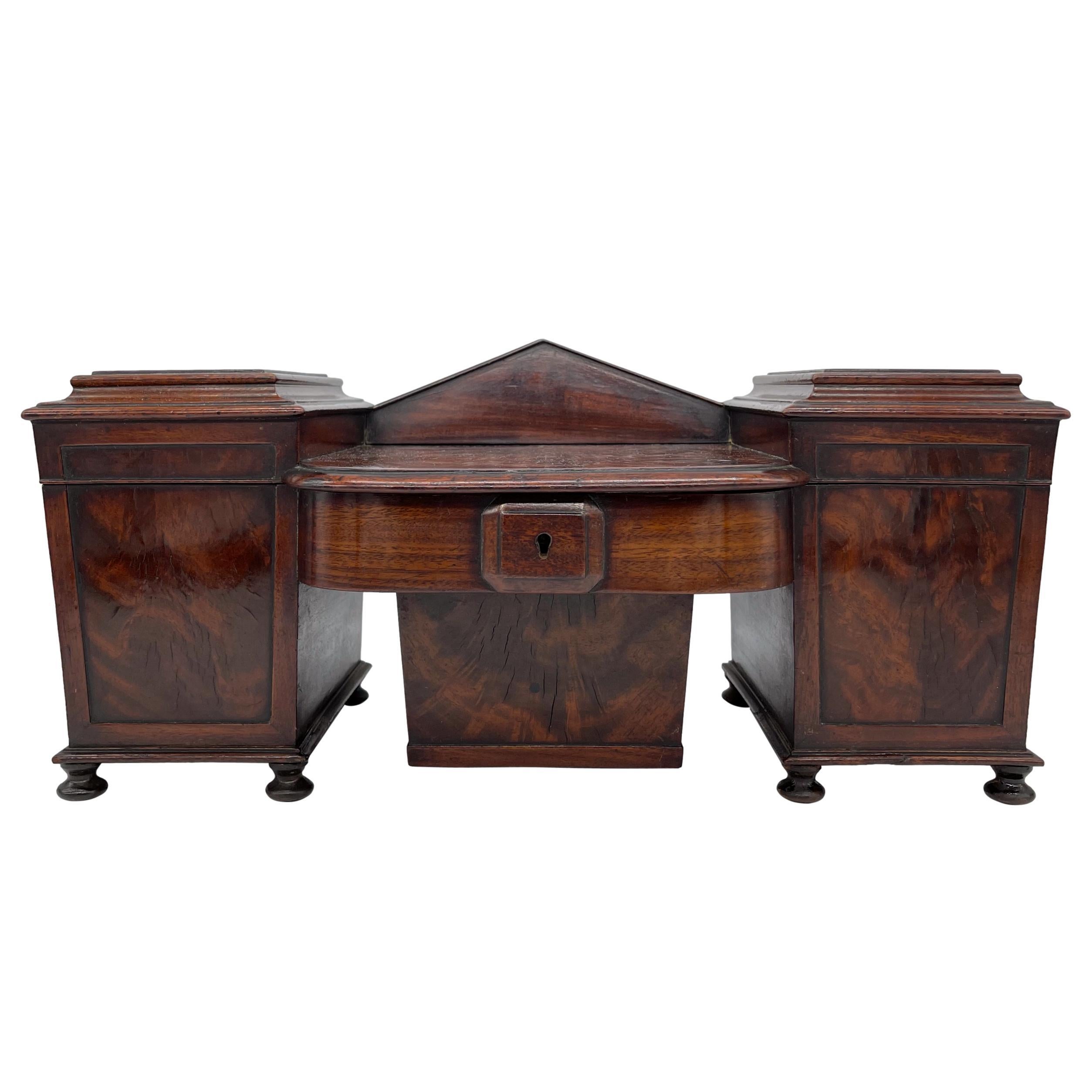 A rare William IV tea caddy in the form of a perfectly scaled model-miniature double pedestal sideboard with Integral Wine Cellaret, the pedestals with molded caddy tops above raised panel doors, the centerboard with a stepped bow front, above a
