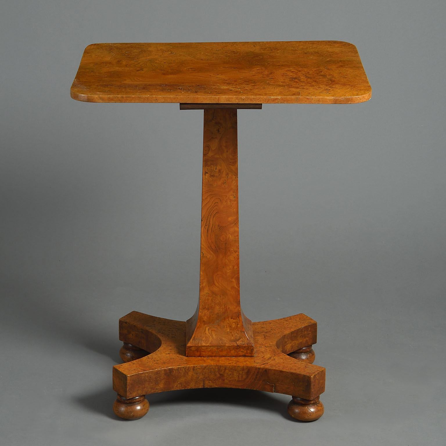 A William IV elm table with rectangular top and concave-sided pedestal base raised on bun feet.