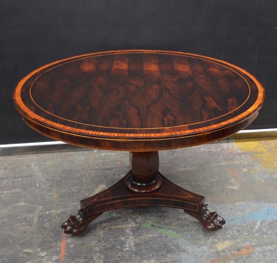 Stately William IV rosewood center / breakfast table with Satinwood Inlay was made in England in the 19th Century. This Extraordinary Tilt-top Center Table has a Multiple book matched Crotch Rosewood veneered circular top with Satinwood banded and
