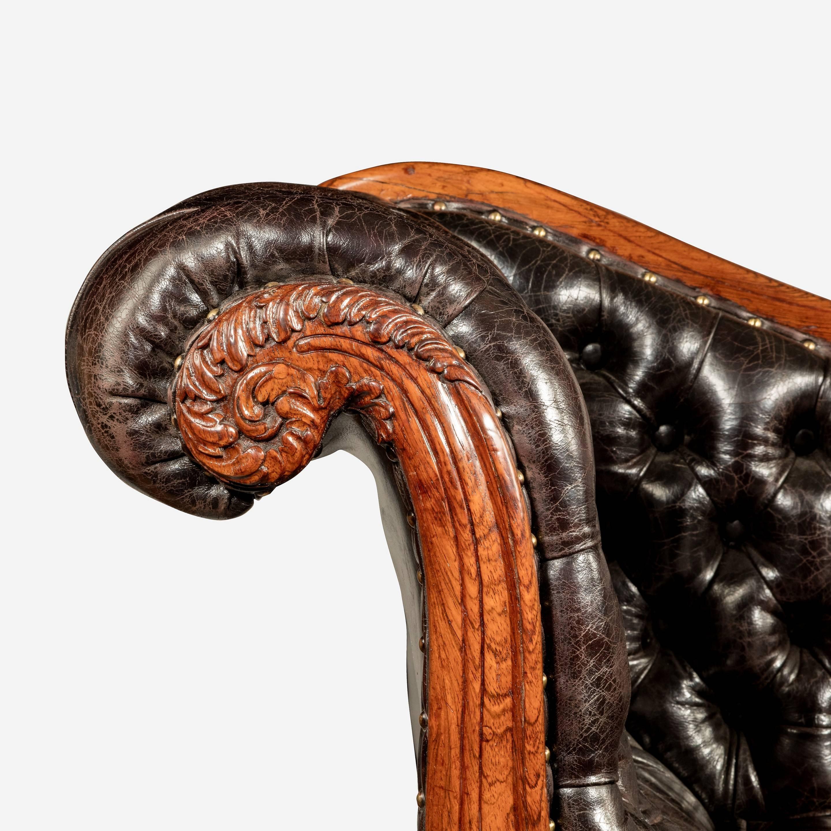 Chaise longue en bois de rose William IV attribuée à Gillows, avec des terminaux et des accoudoirs en volutes profondément sculptés, et des pieds fuselés tournés sur des roulettes déguisées.