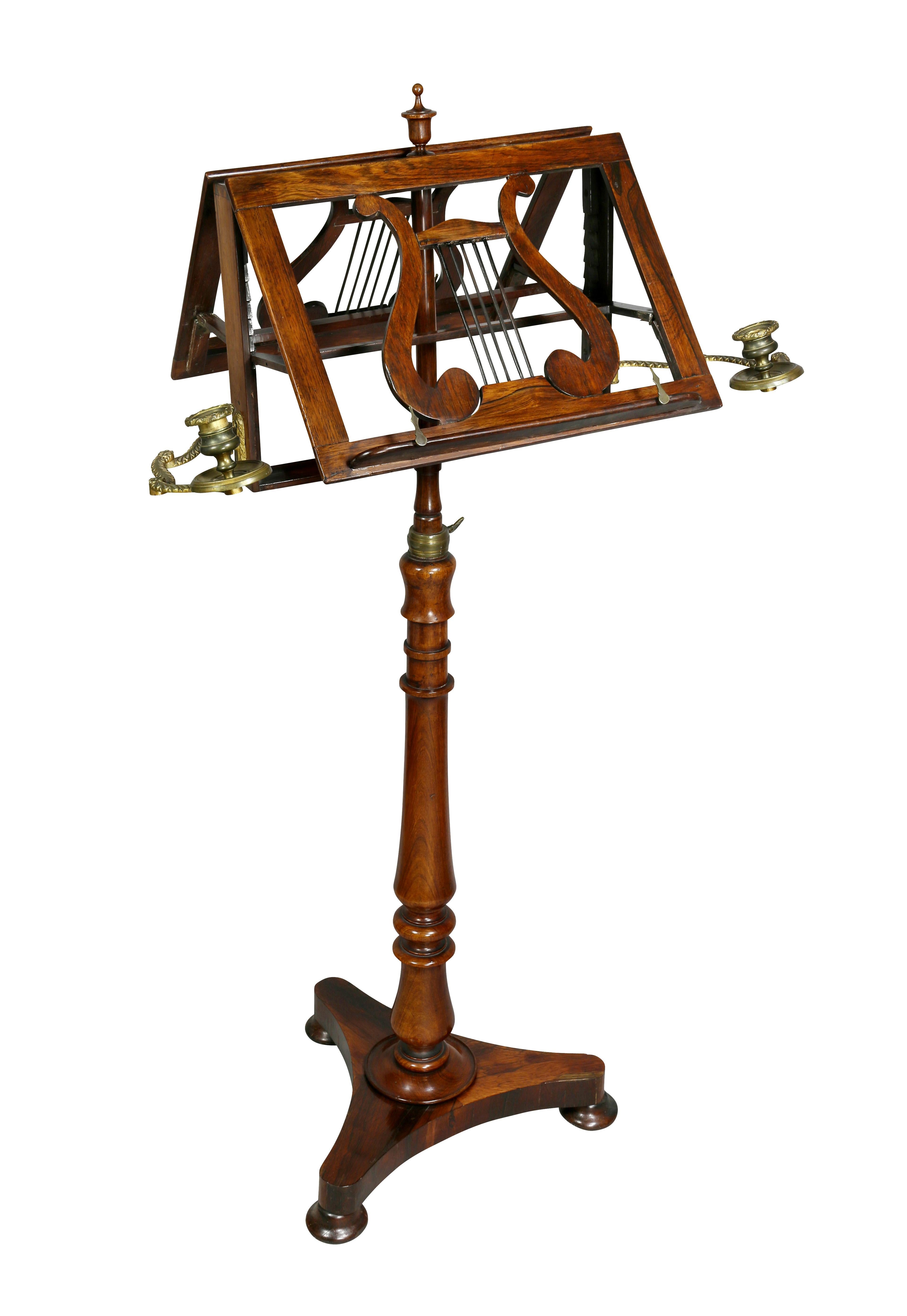 With urn finial over a double sided Lyre form sheet music or book holder, with pair brass adjustable candlearms, turned support ending on tripartite base and flattened circular feet.