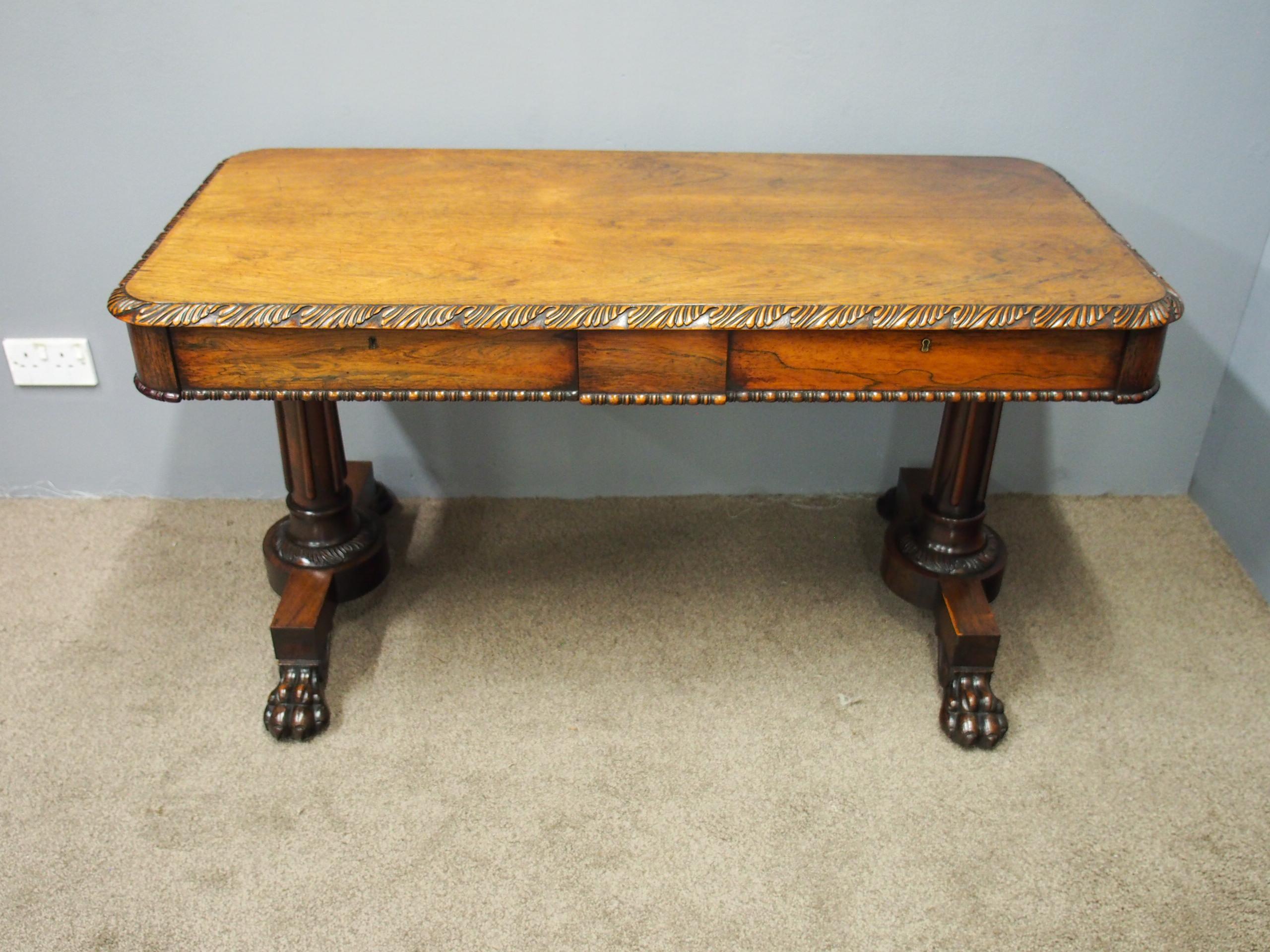 Exhibition quality rosewood library table of the William IV period, circa 1830. The rectangular shaped table has a profusely carved, gadrooned edge which continues on all sides. The front frieze has two drawers, and there are dummy drawers to the