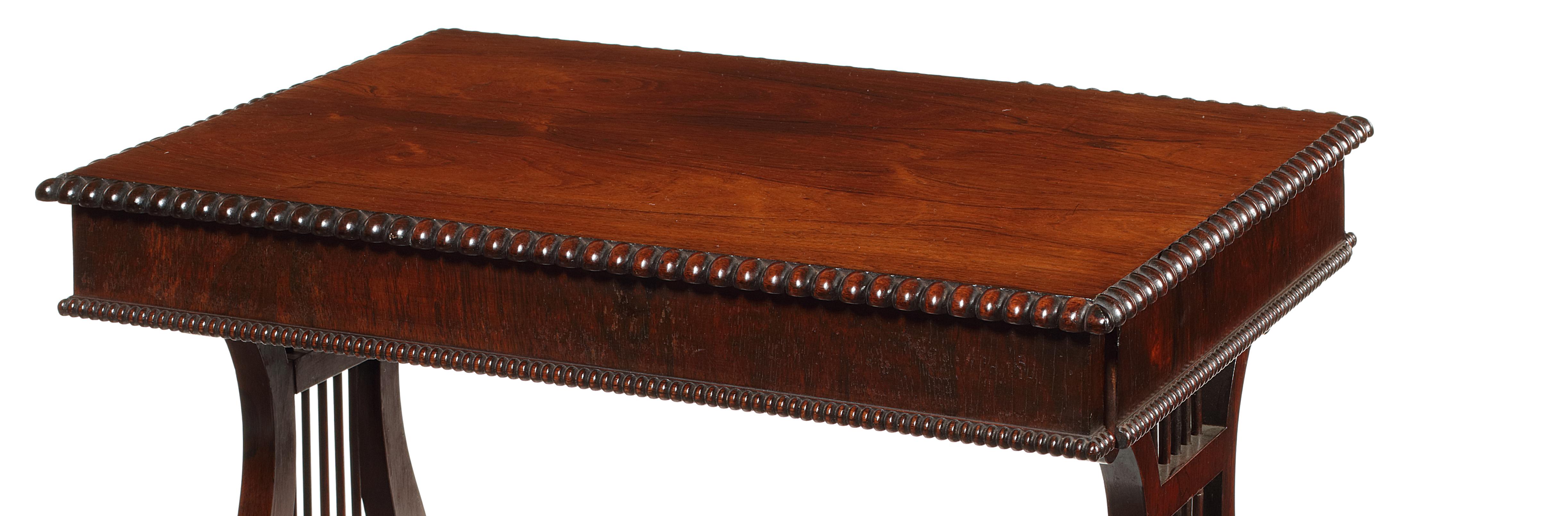 The rectangular top with beaded edge above two drawers to each side, on spindle turned lyre-end supports, on cabriole leaf carved legs and scroll feet with castors, the sliding frame for a work bag existing, but fixed closed.

With similarities to