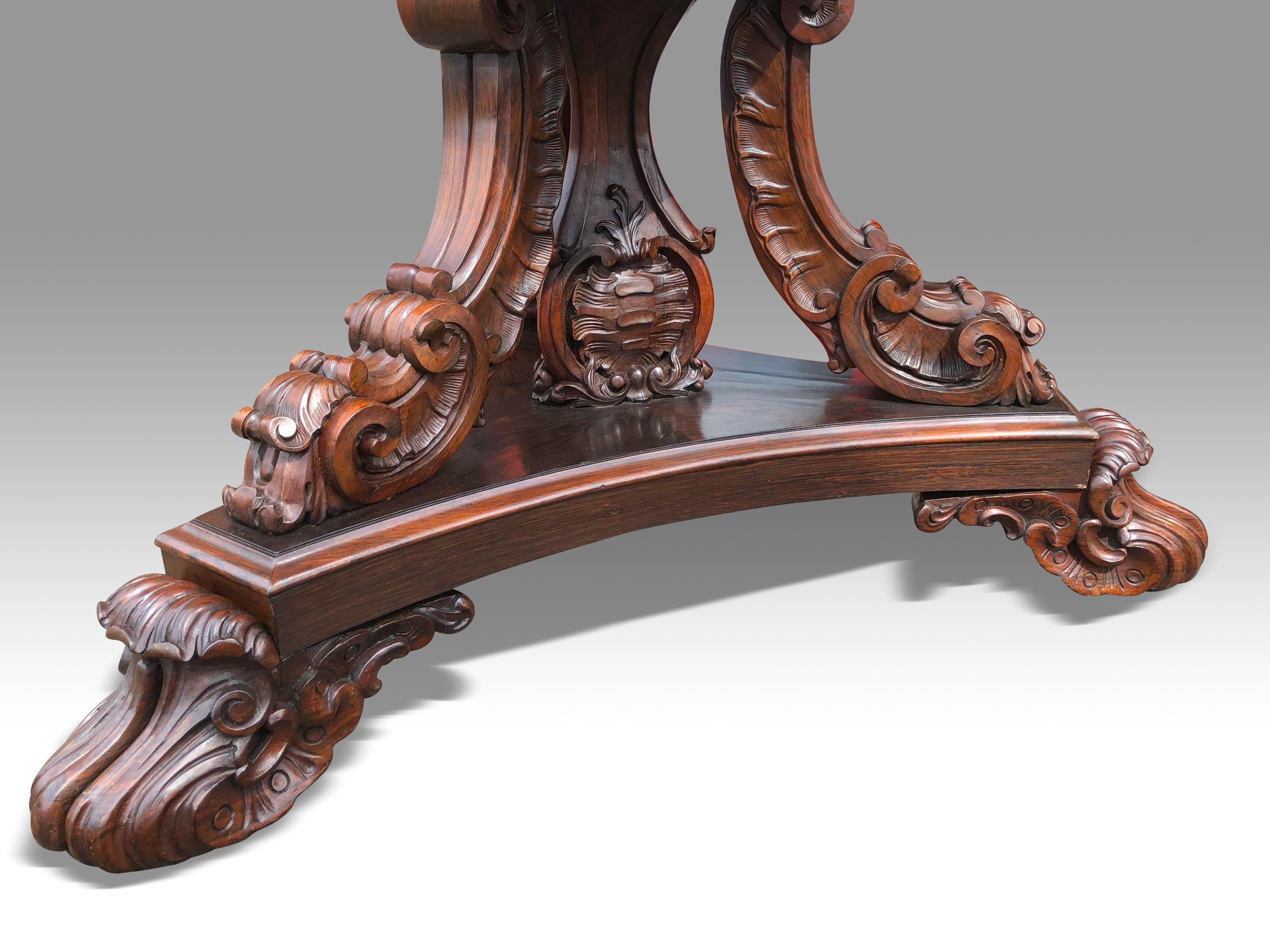 An impressive large scale William IV rosewood octagonal centre table.
The three boldly carved solid rosewood scrolled supports and carved central pedestal on a tri-form base with generously carved rosewood feet with concealed castors.
