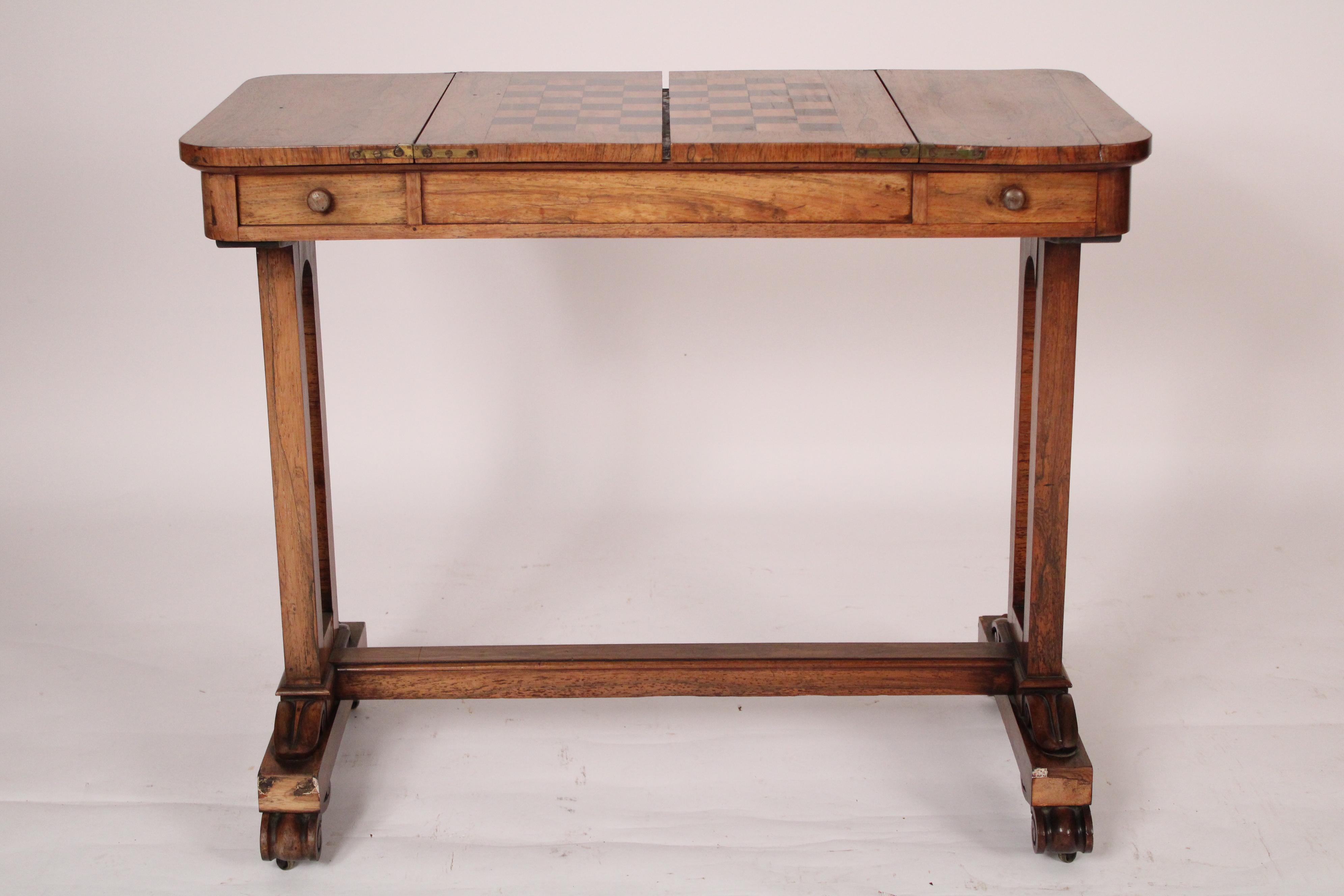William IV rosewood writing / games table, circa 1830. With a rectangular rosewood top with rounded corners, a beech wood and rosewood inlaid checker board that lifts up to a leather backgammon board, frieze 
drawers on left and right sides,
