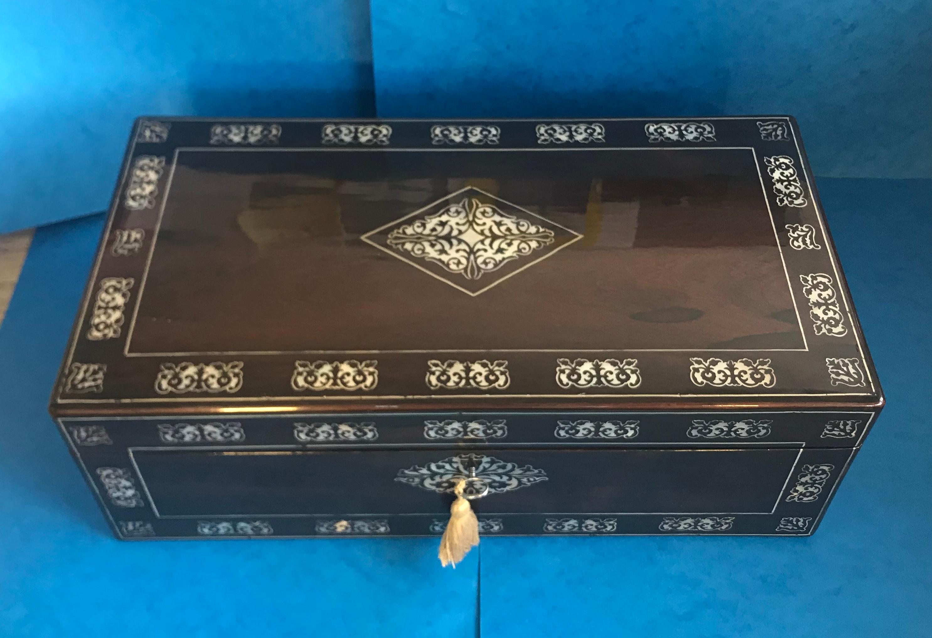 William IV rosewood writing slope.
A stunning wringing slope that dates back to circa 1830, it’s beautifully inlaid with a pewter and mother of pearl pattern. The writing slope has a fully working lock and tasseled key. It has military handles to
