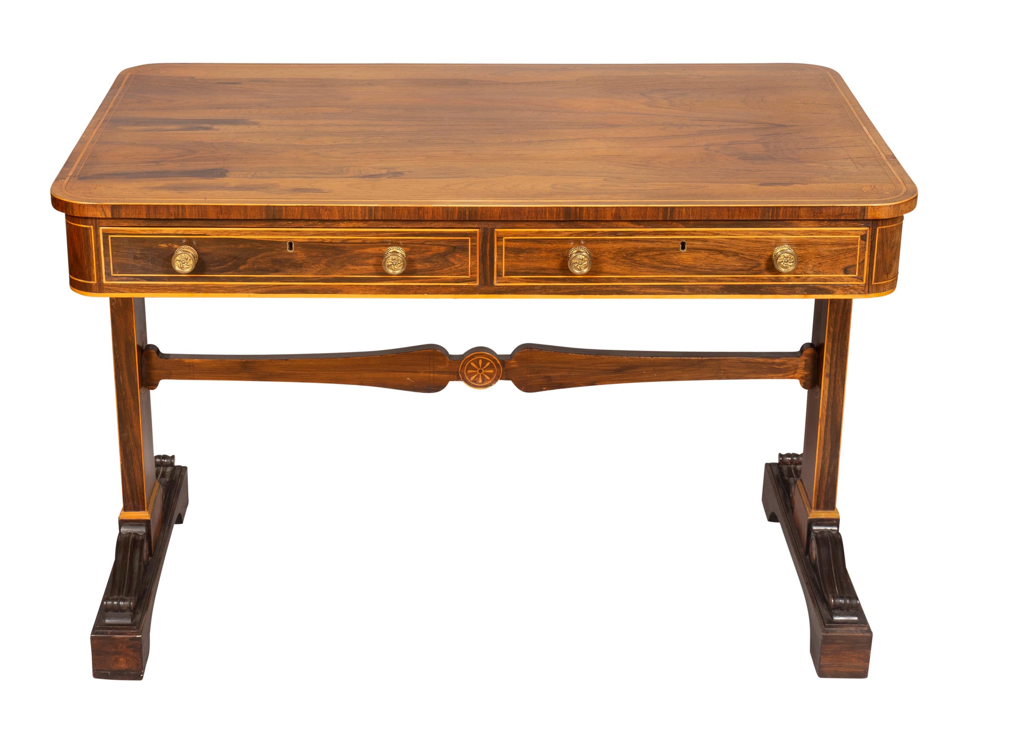 Rectangular top with rounded corners and string inlay above a pair of drawers with opposing false drawers raised on a trestle base with roundel satinwood inlays. Shaped stretcher and legs with carved volutes.