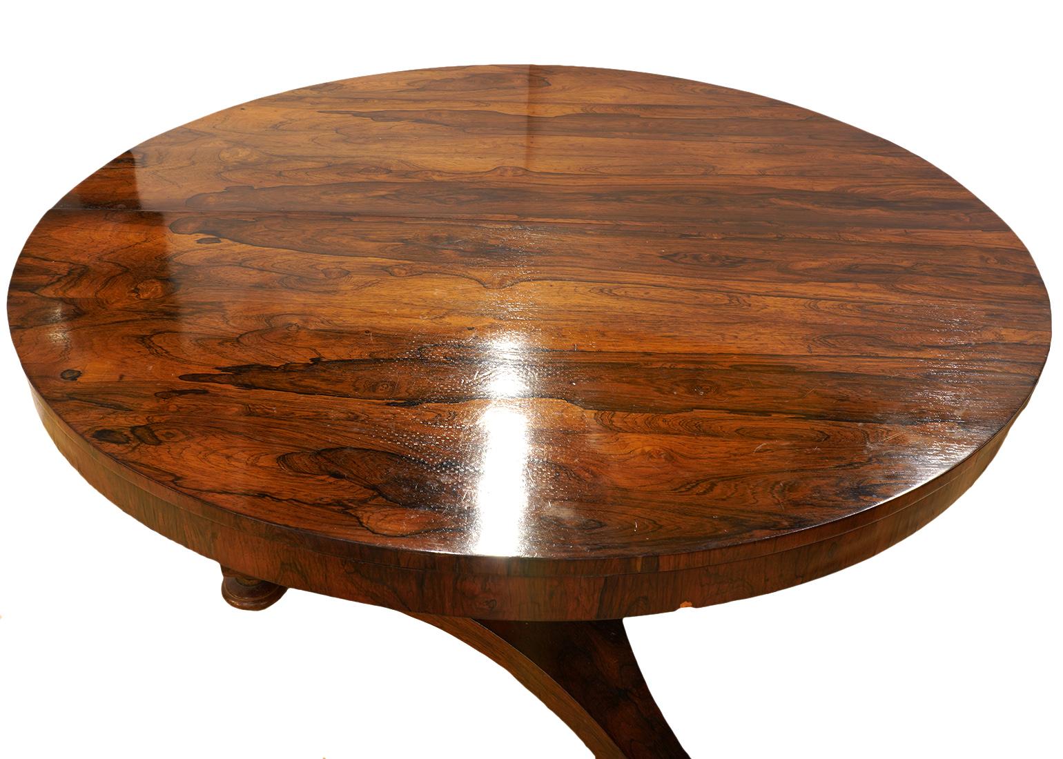 This good William IV rosewood pedestal center table or dining table features a round polished bookmatched figured top on a slightly tapering hexagonal pedestal on a triangular base resting on turned feet.