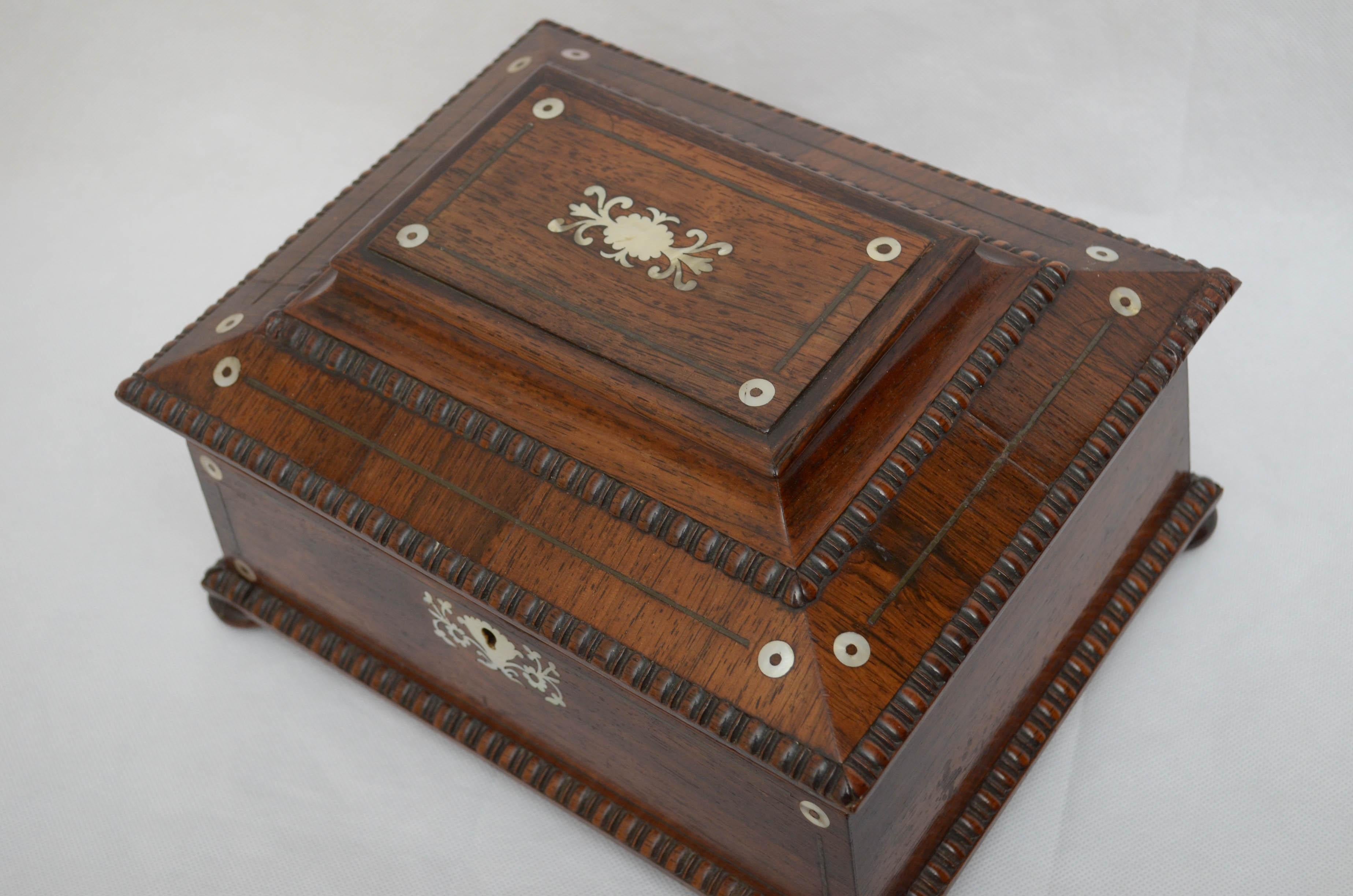 K0123, stunning William IV rosewood work box / jewelry box, having quadrant beading ad mother of pearl inlaid to the front and to the hinged top which opens to reveal relined interior with a lift up tray, all standing on bun feet. This antique box