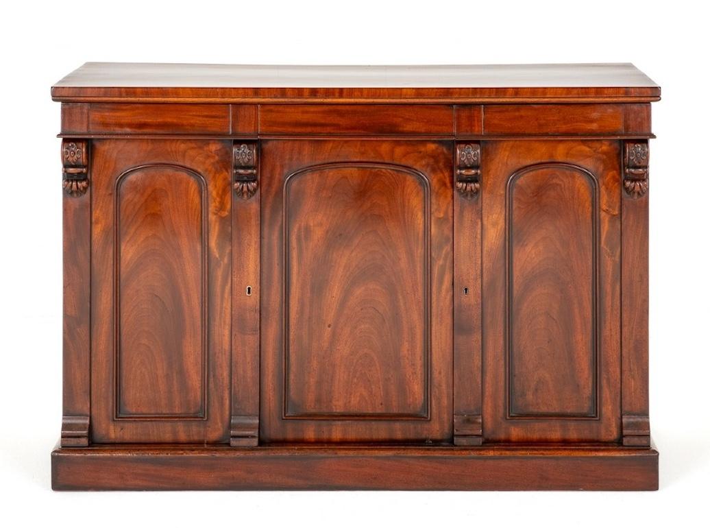 William IV mahogany 3 door side cabinet. This rather impressive side cabinet stands upon a plinth base. The 3 doors feature arched moldings with wonderful flame mahogany timbers. The columns having carved corbels.
The doors open to reveal a