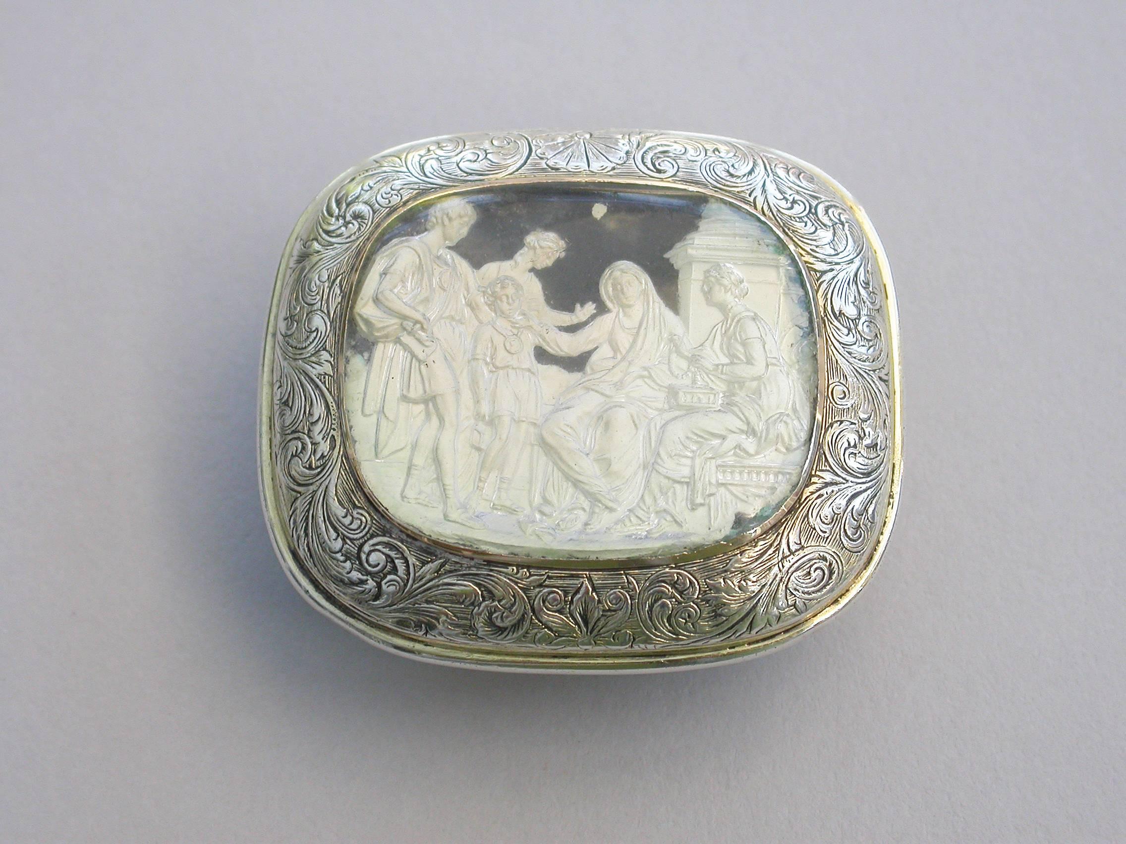 A superb and rare William IV cushion shaped silver vinaigrette with pale gilding, the lid set with a classical Roman scene in white slip under a domed crystal cover depicting; “Cornelia, Mother of the Gracchi”, framed by engraved feather scrolls